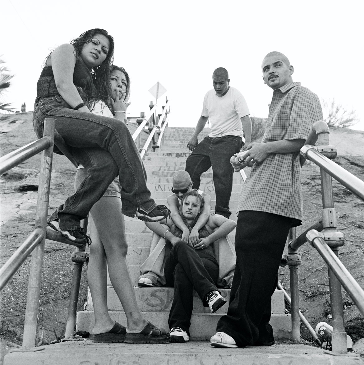 a group of friends pose in a stairwell in east la