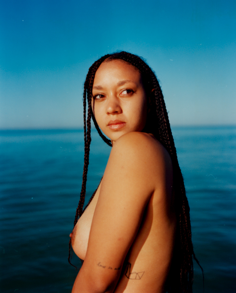 a topless woman stood in the sea