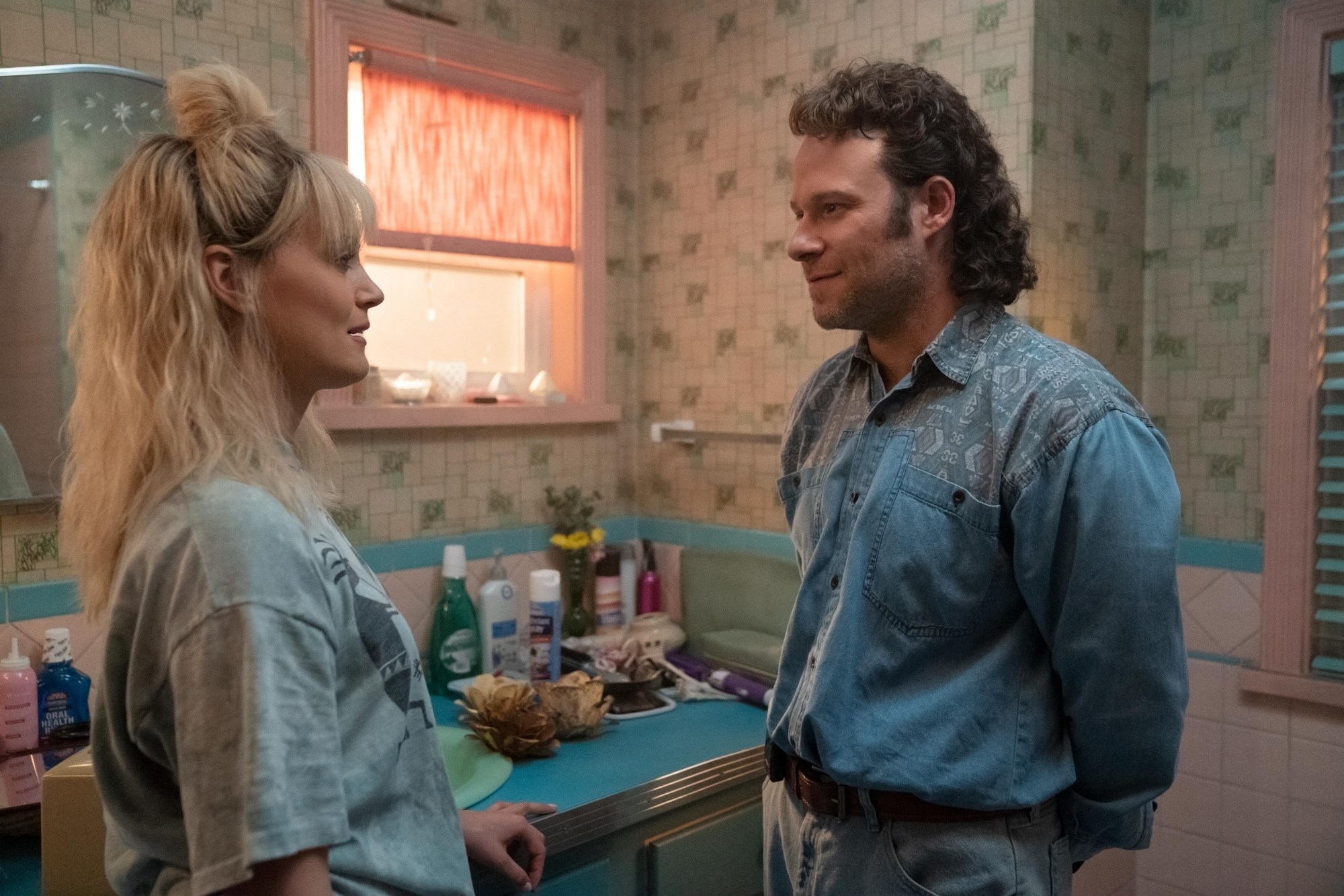 Taylor Schilling and Seth Rogen in 'Pam & Tommy' as Erica and Rand talking in the bathroom.