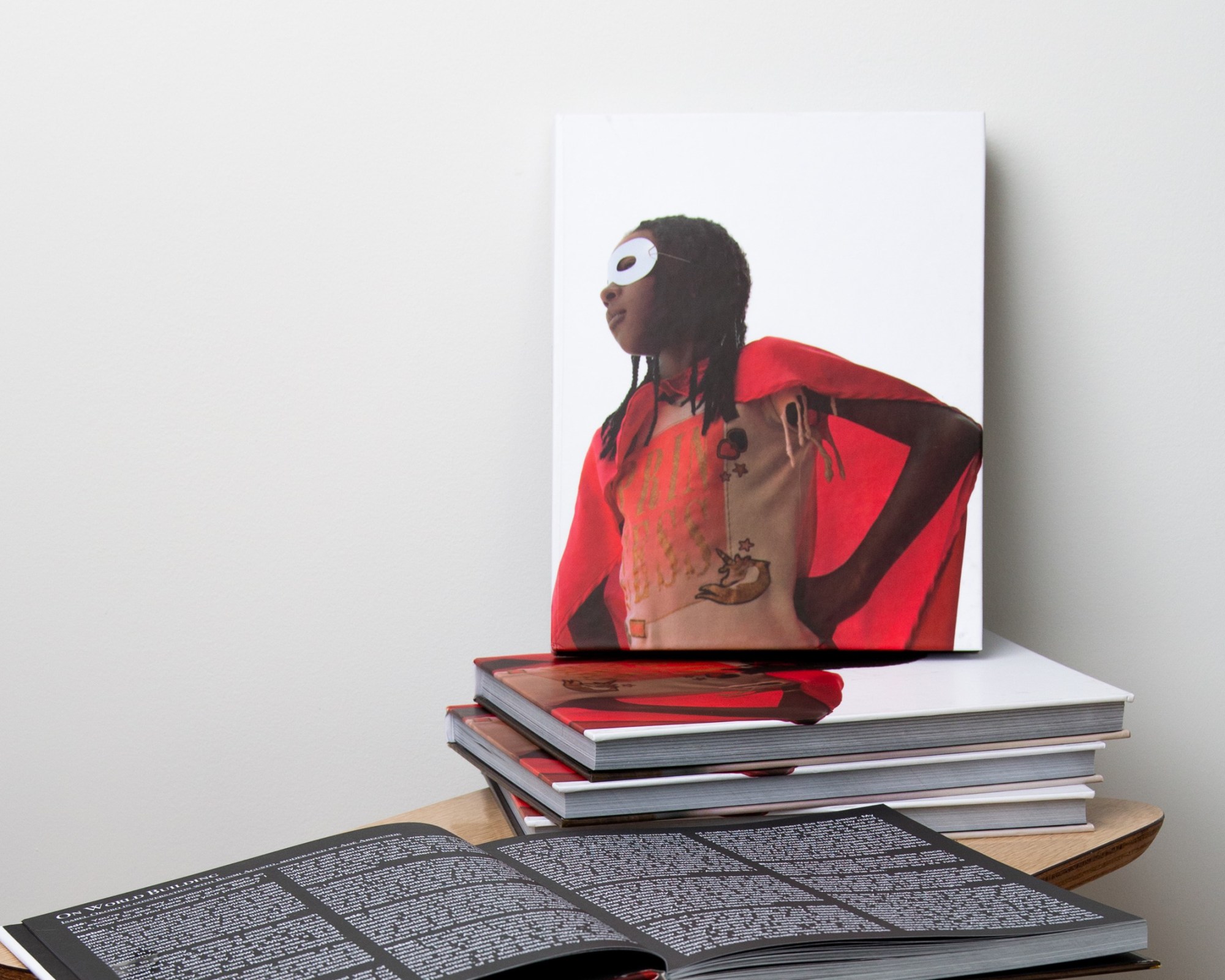 a pile of photobooks featuring an image of a child dressed as a superhero