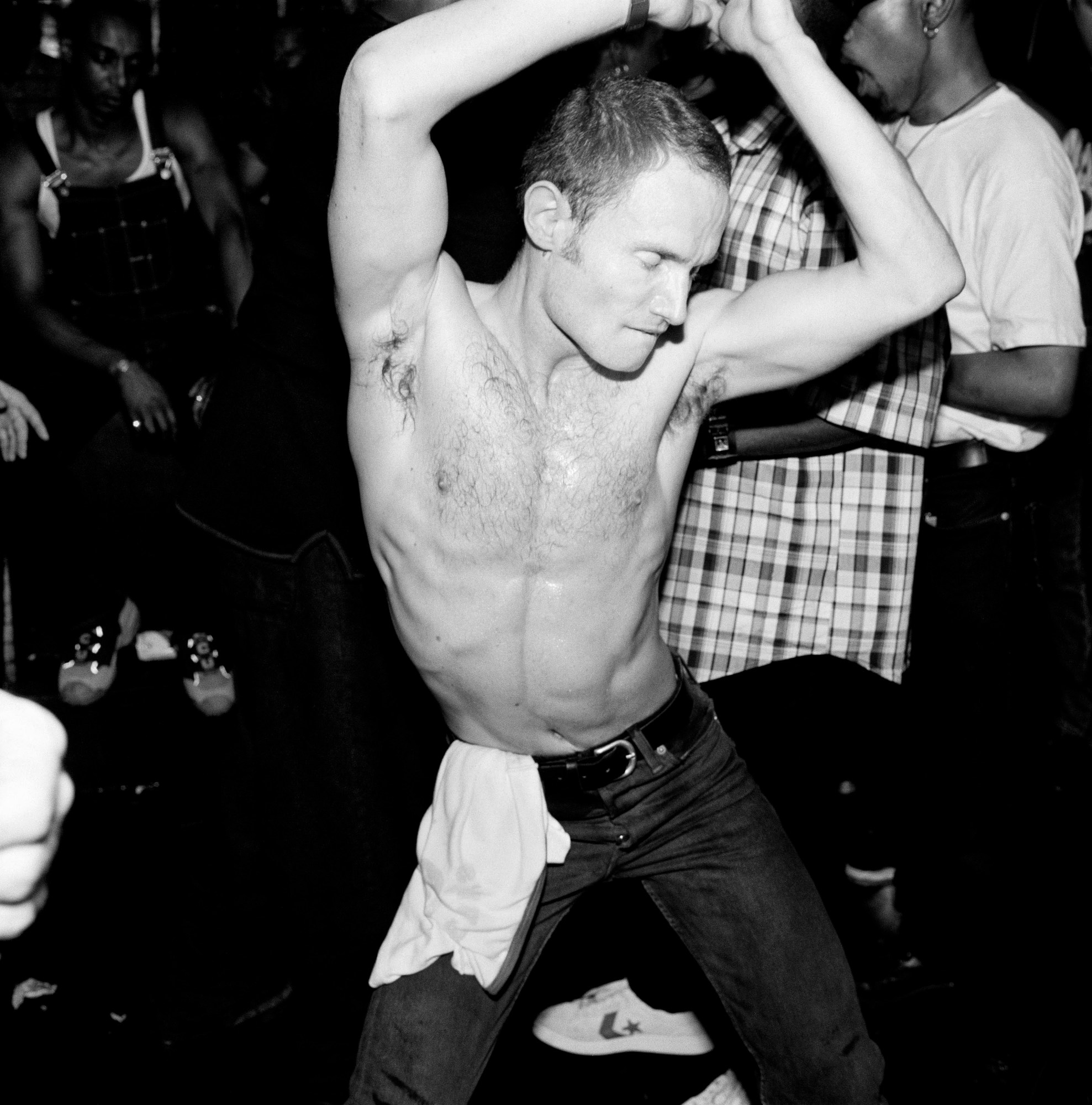 Topless man dances in black and white photo