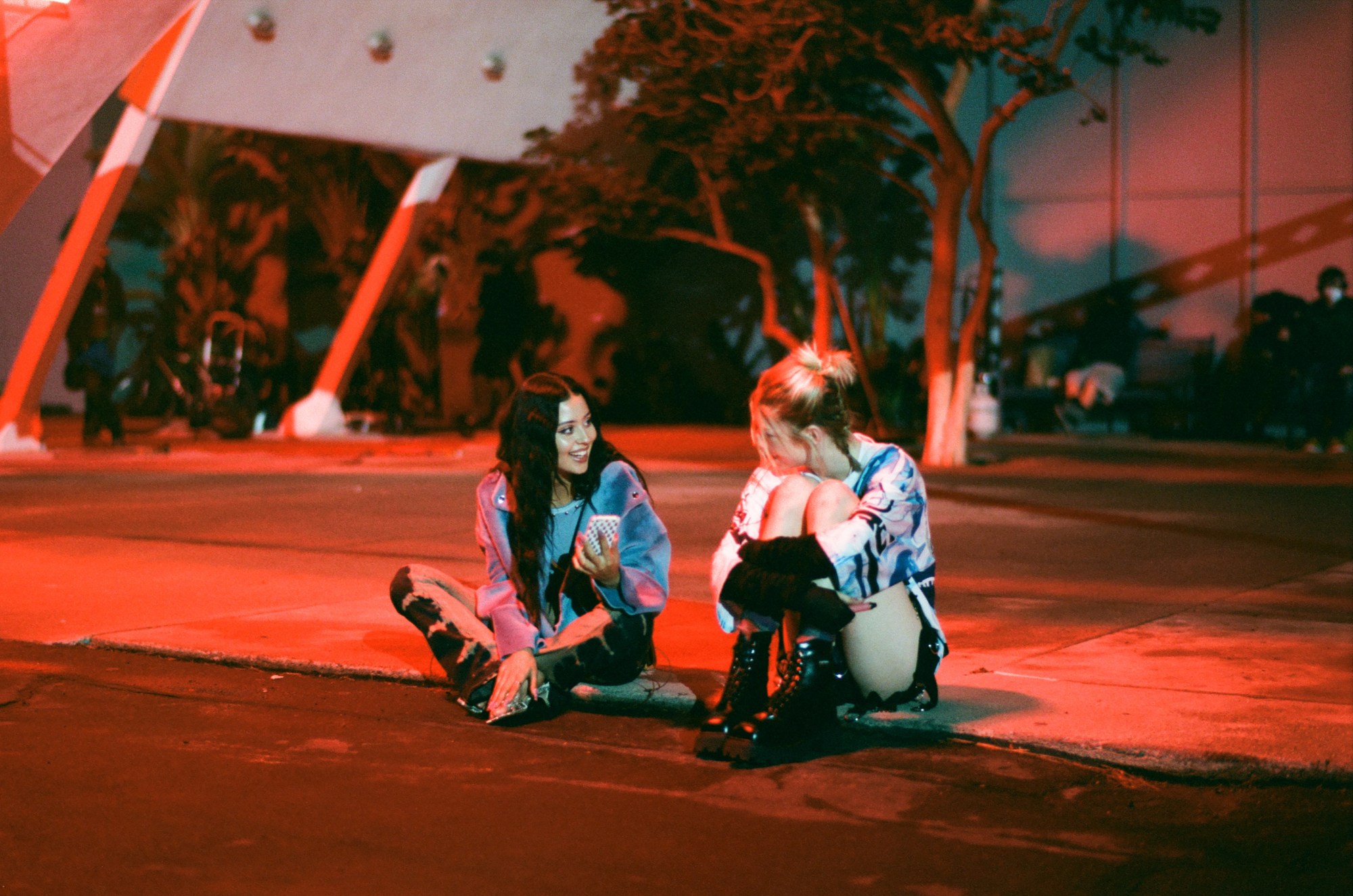 Alexa Demie and Hunter Schafer on red lit pavement