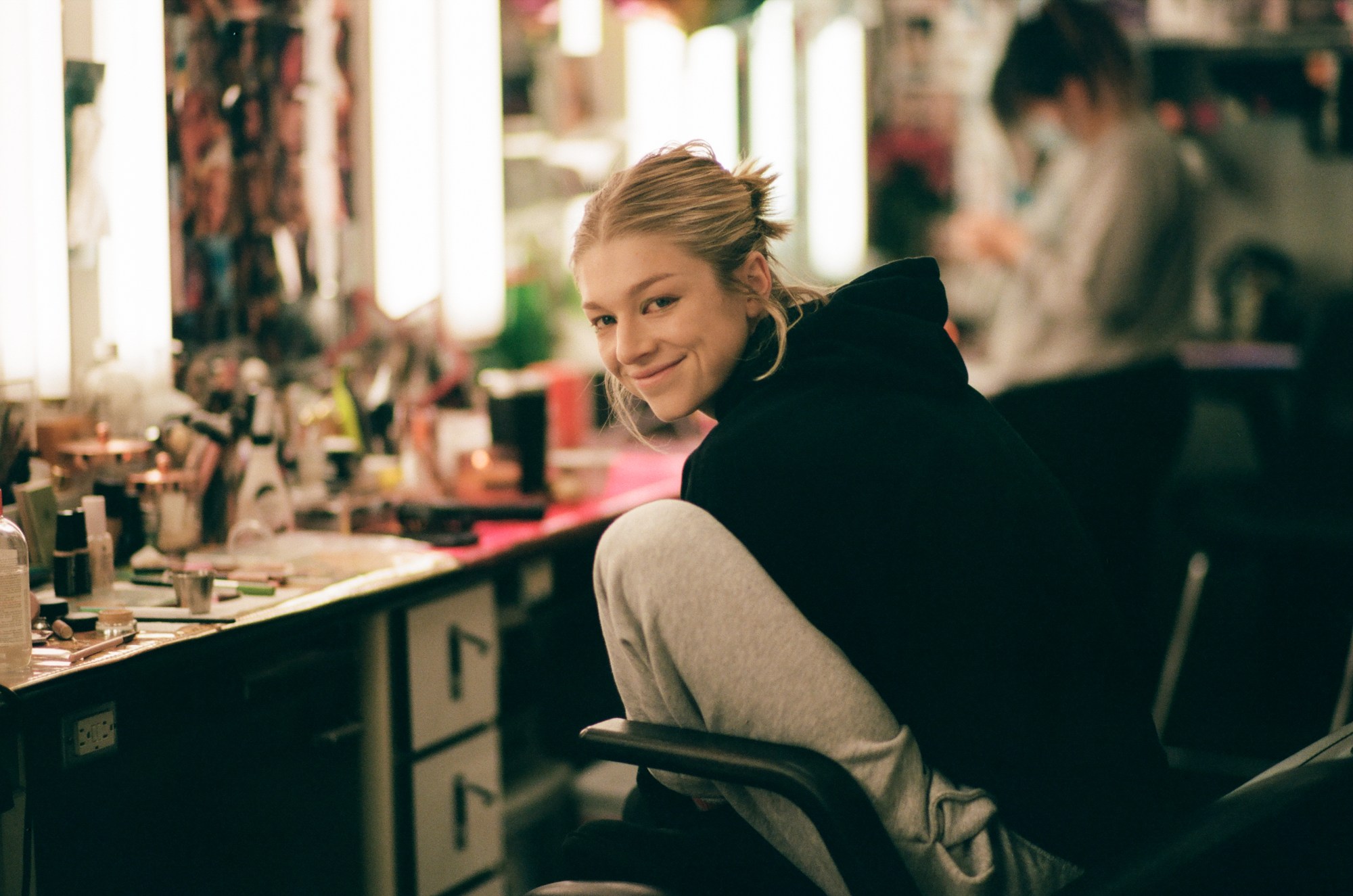 Hunter Schafer smiles while in the makeup chair