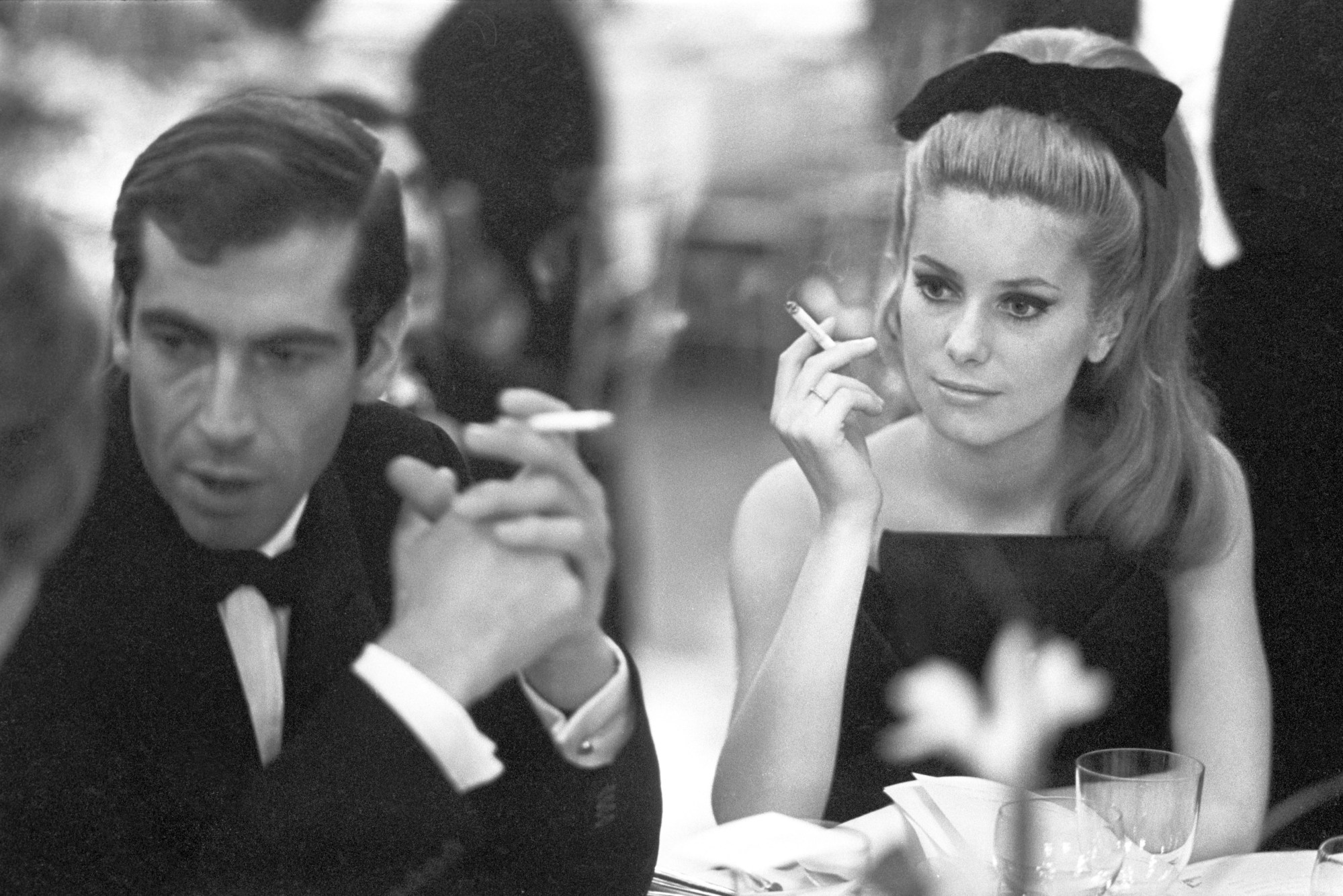 catherine deneuve smoking a cigarette with a bow in her hair and roger vadim