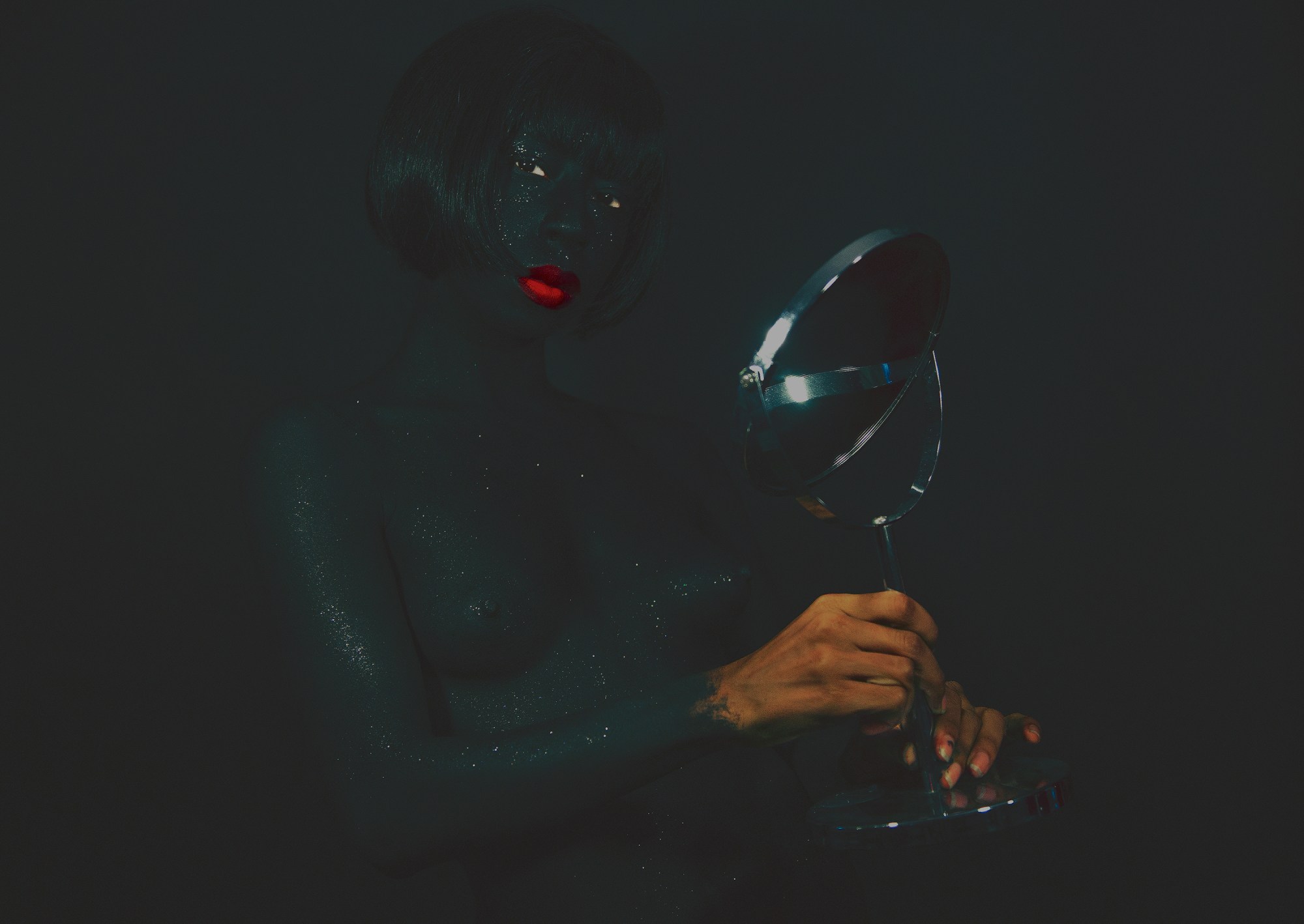 a self-portrait of kia labeija covered in black glitter and wearing red lipstick