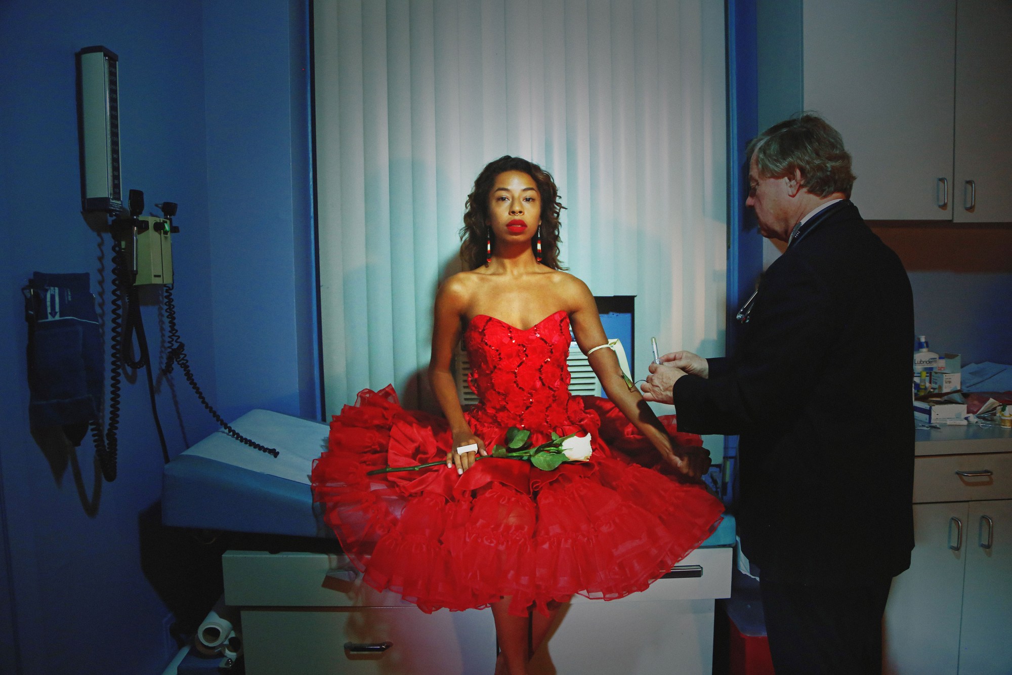 kia labeija self-portrait in a red prom dress at the doctor's office