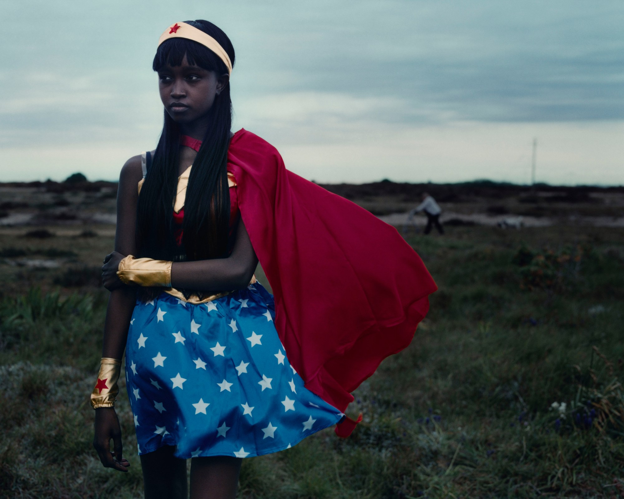 a wonder woman cosplayer standing in a field