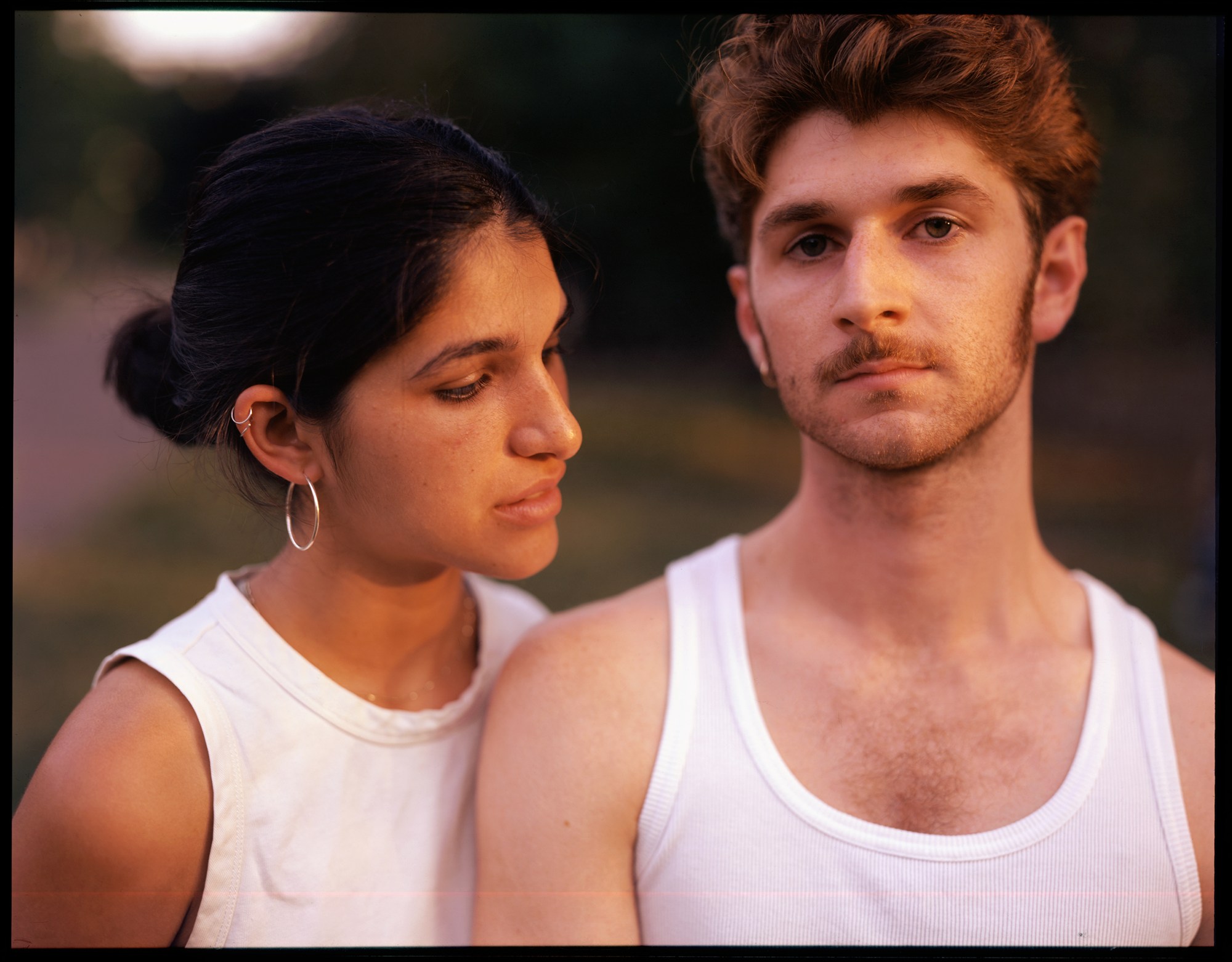 a portrait of a couple wearing white tank tops by ian lewandowski