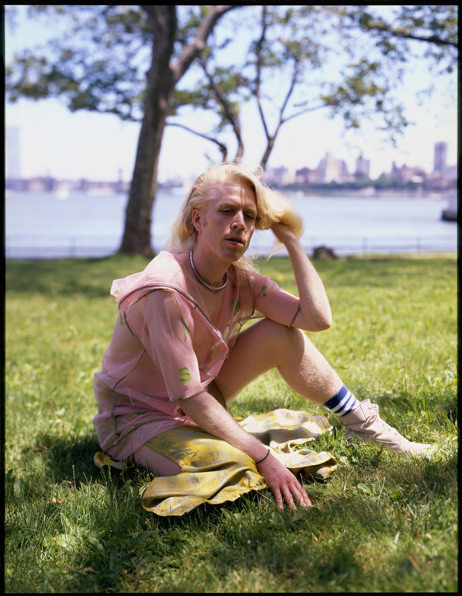 portrait of a man sitting in the grass by ian lewandowski