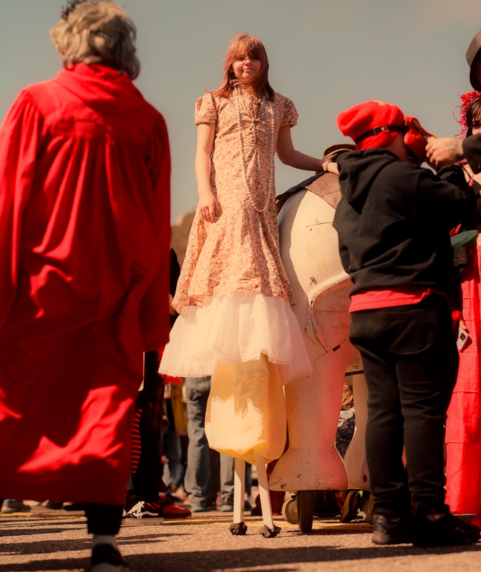 Young girl standing on stilts at a carnival.