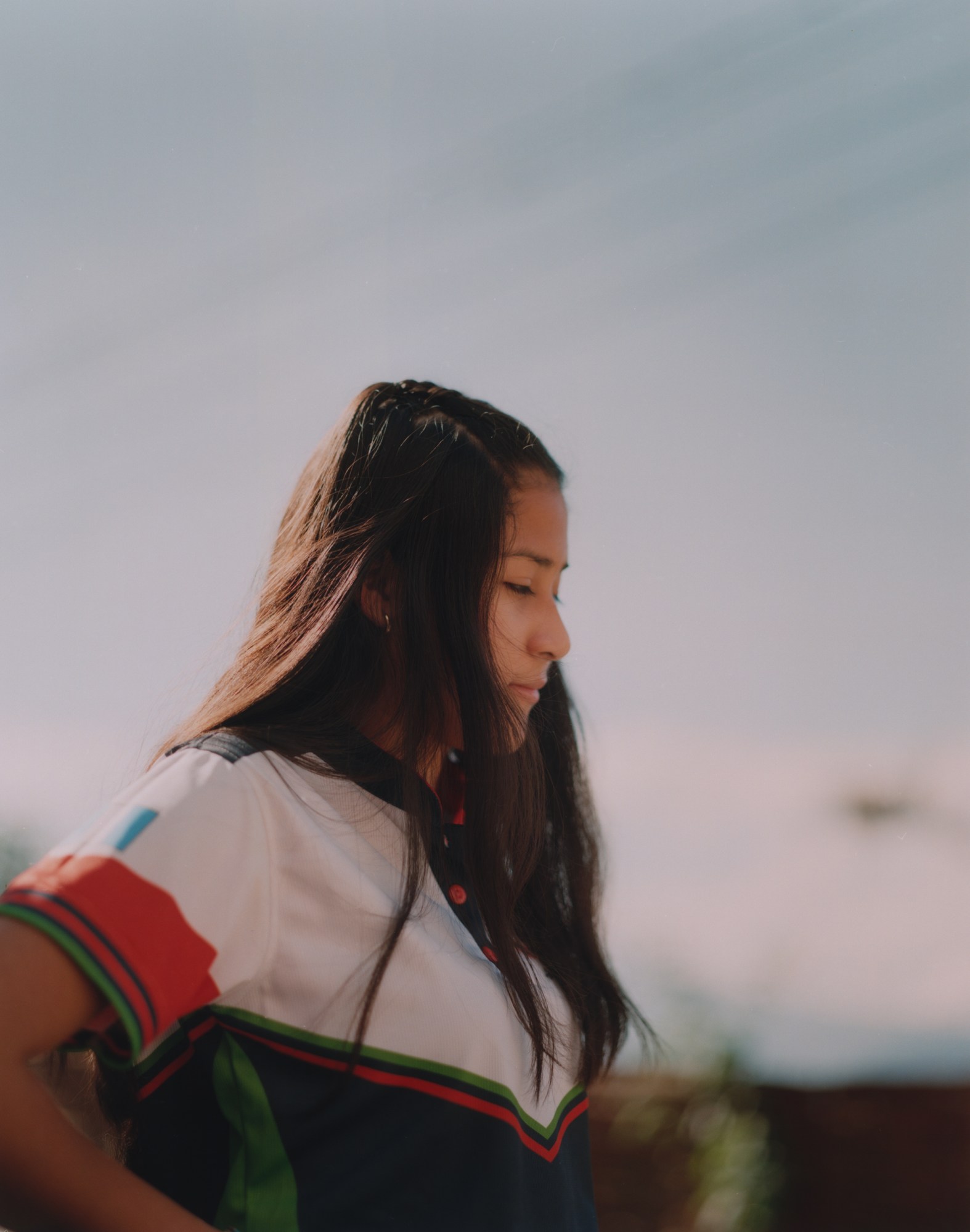 Portrait of a young girl in a colourful polo top.