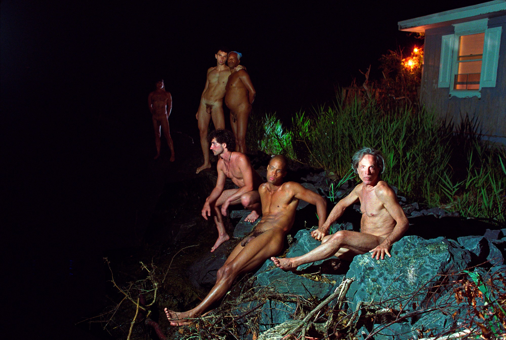 nude men across the rocks of a beach