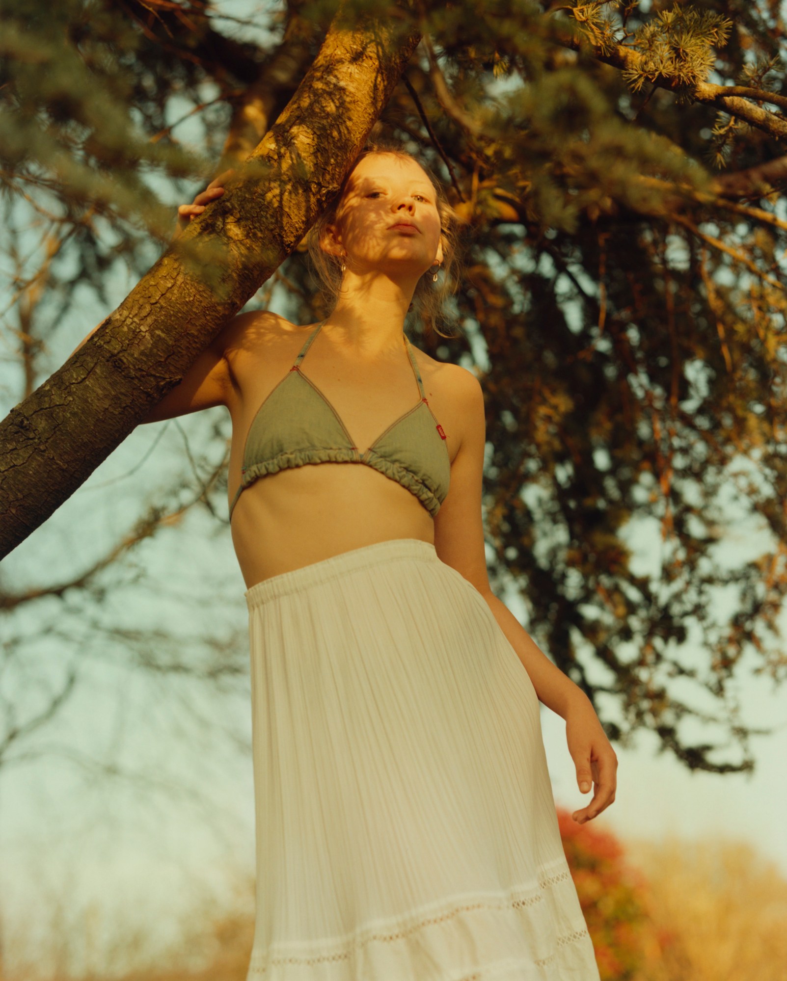 Francesca Allen portrait of her sister, Alida standing by a tree in a bikini top