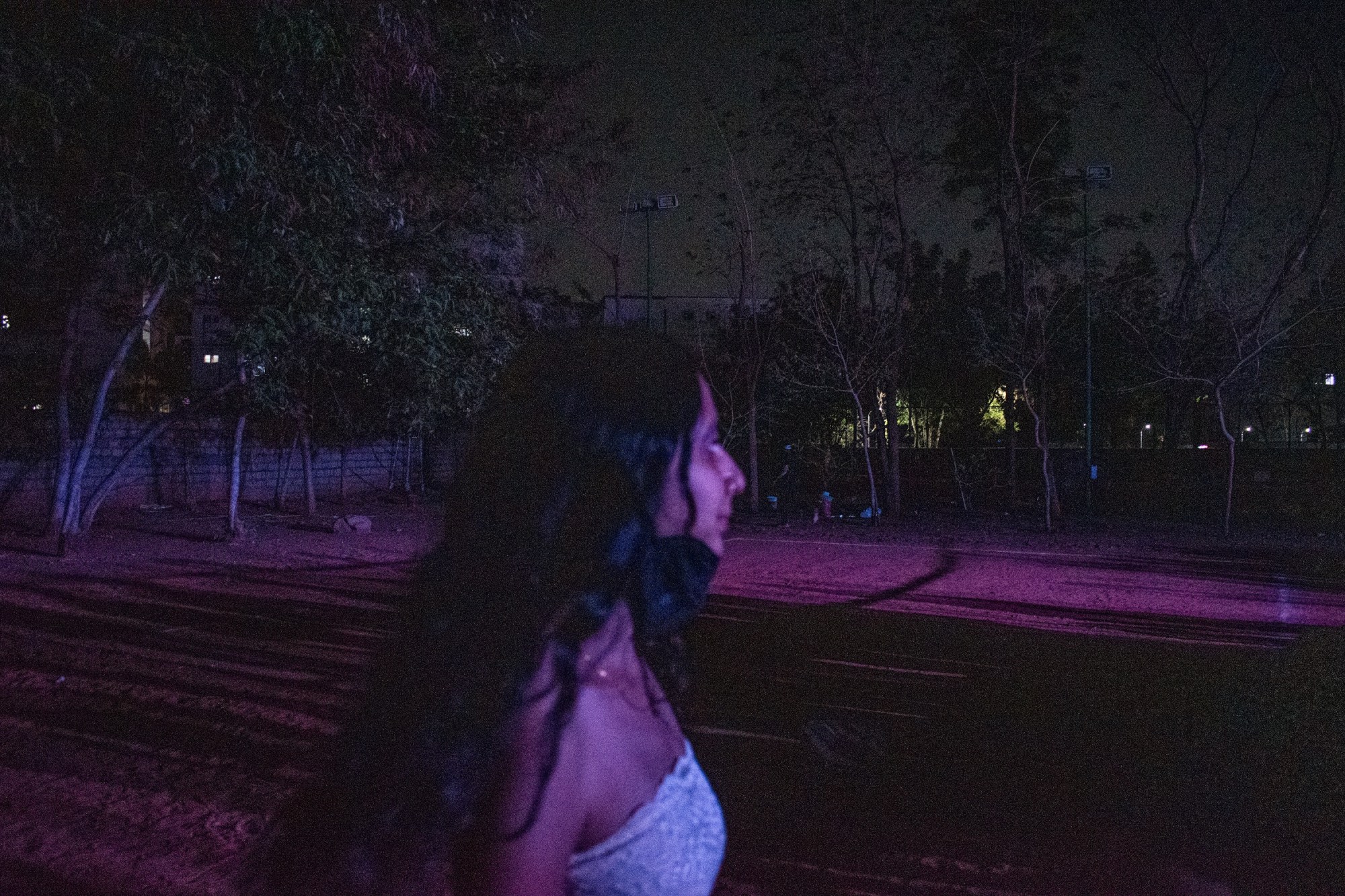 girl walking through a field at night.