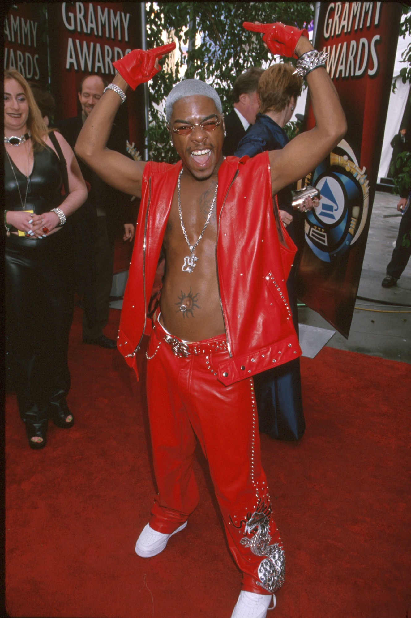 sisqo posing on the red carpet at the grammys 2000 in a red leather vest and pants