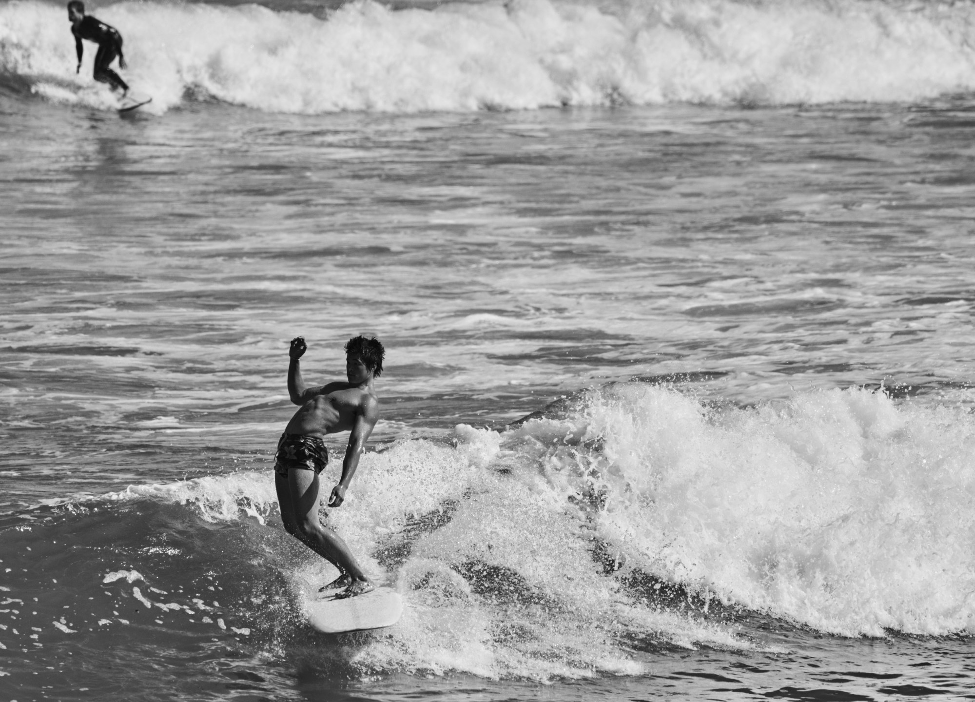 Two surfers riding waves.