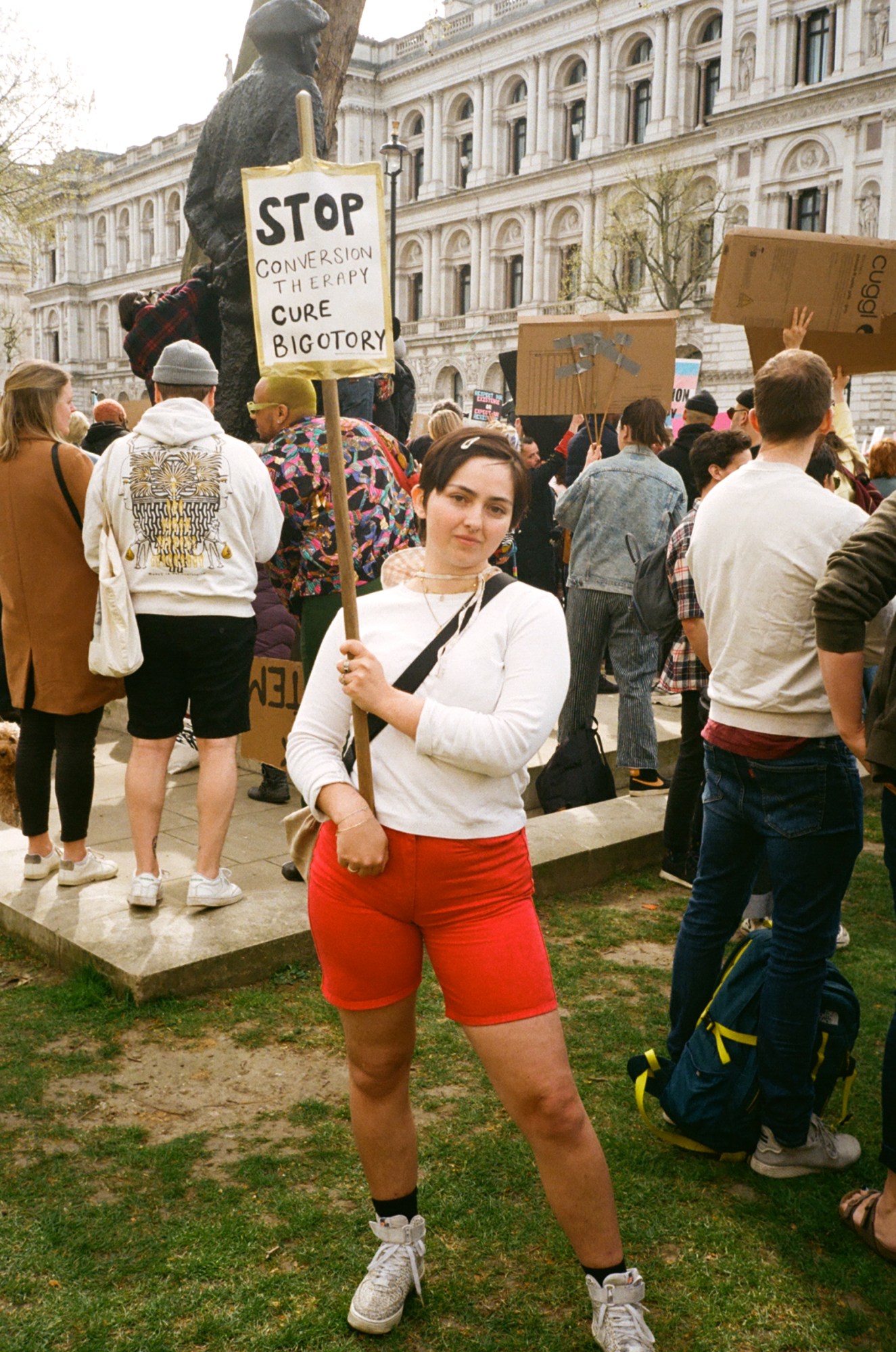 Protester with a sign saying 'stop conversion therapy cure bigotry' at the ban trans conversion therapy protest at Downing Street, London.