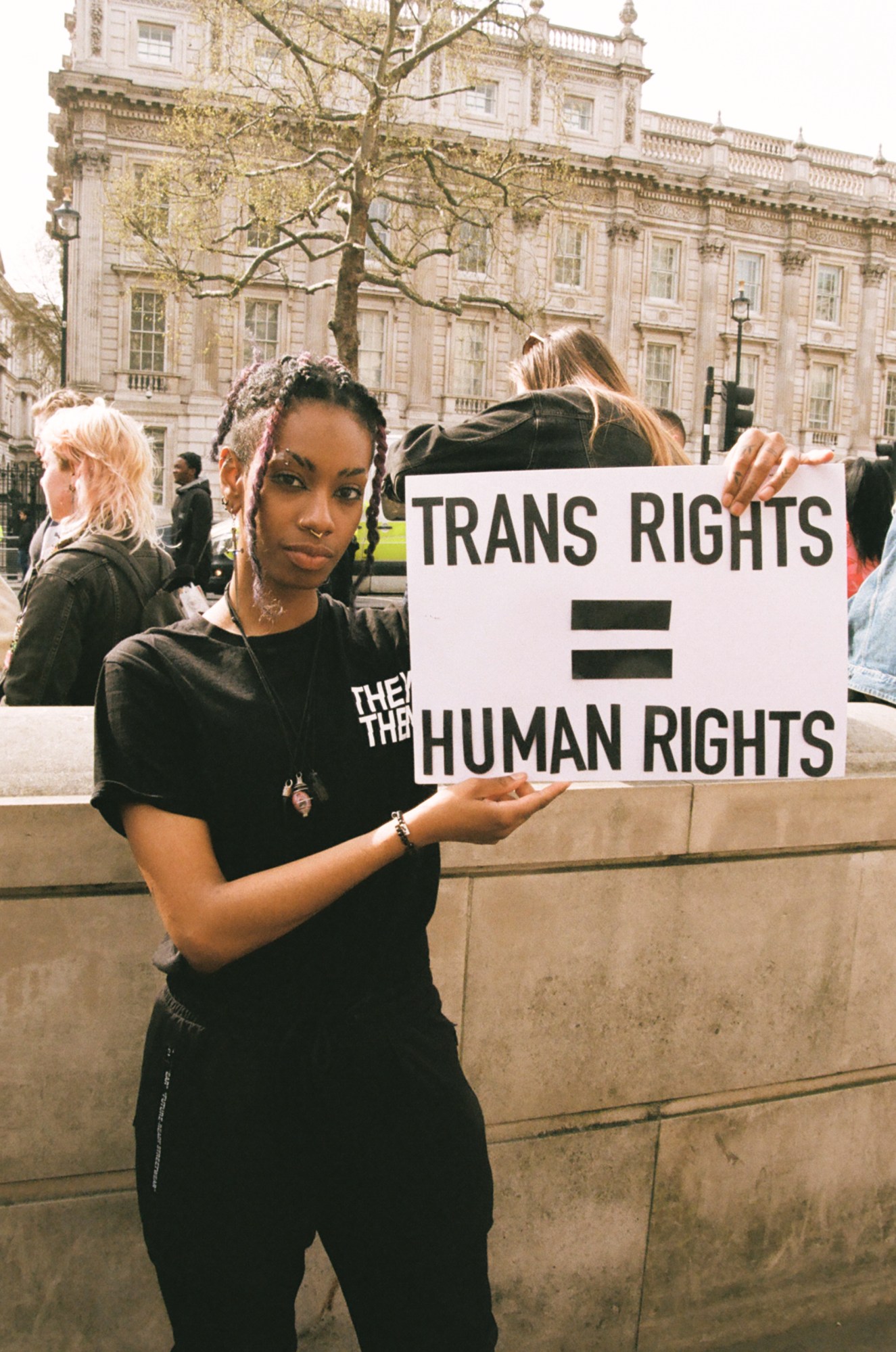 Protester with 'trans rights = human rights' sign at the ban trans conversion therapy protest at Downing Street, London.