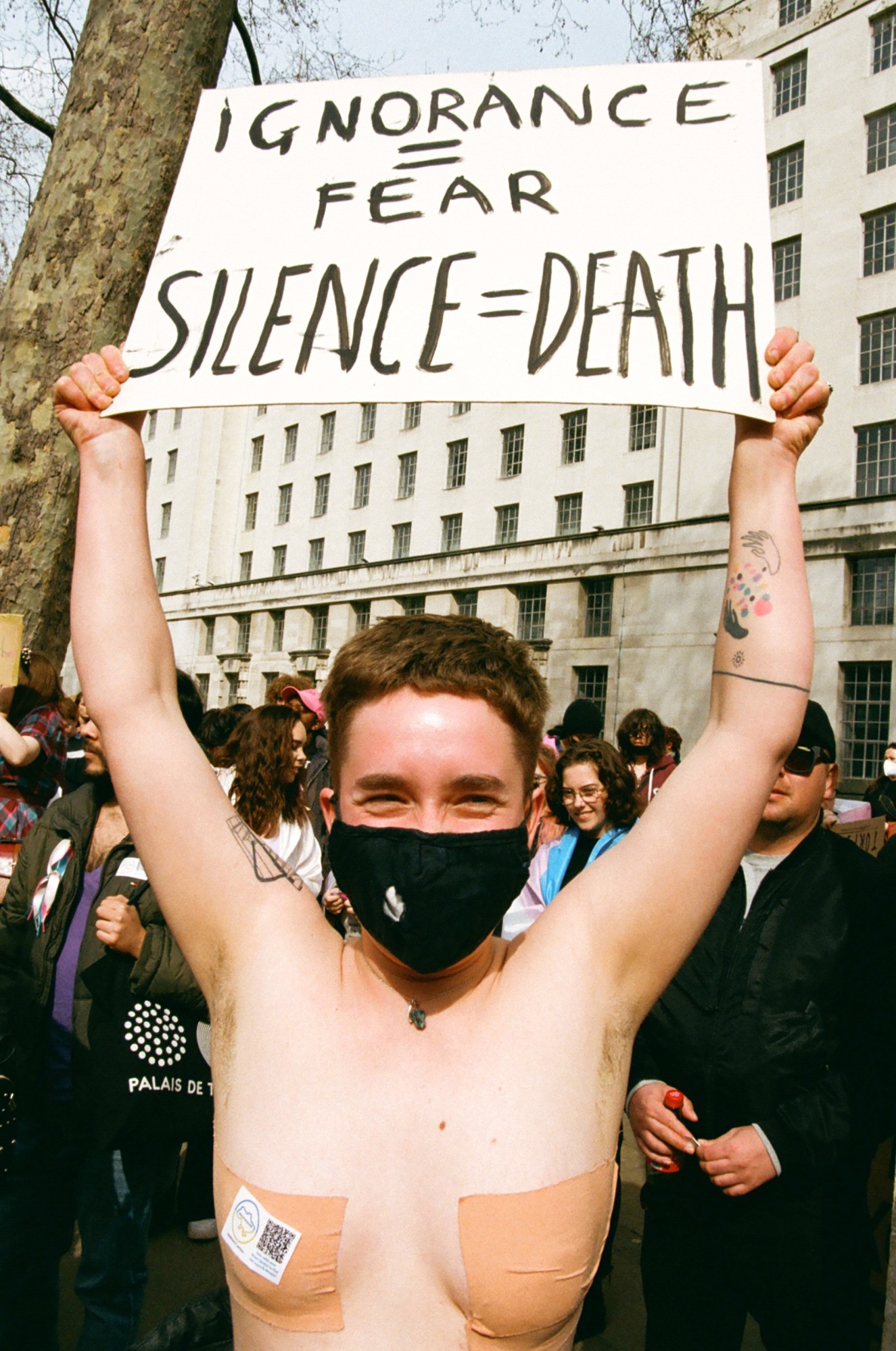 Protester with 'Ignorance = Fear. Silence = Death sign at the ban trans conversion therapy protest at Downing Street, London.