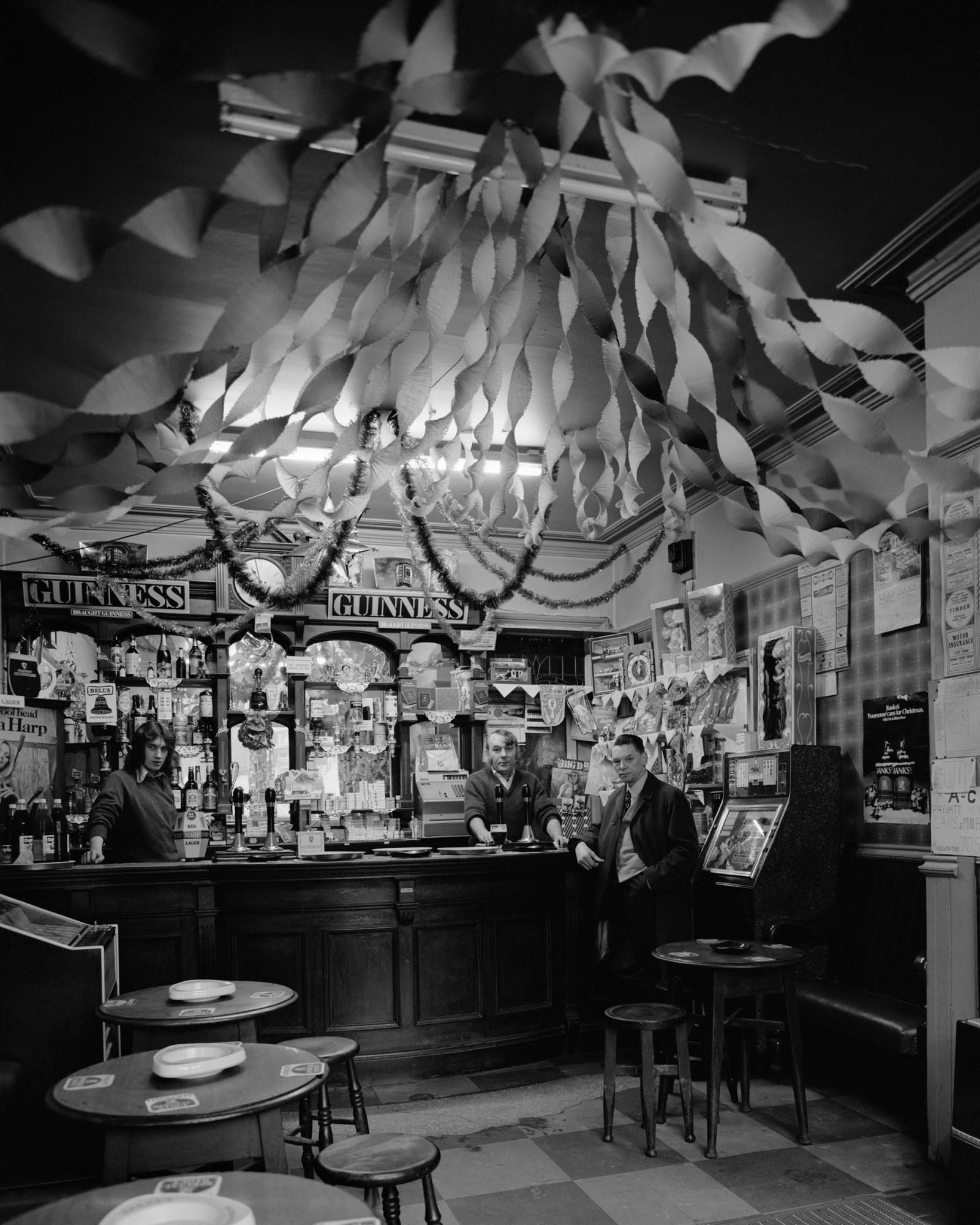 three men around the bar in a pub