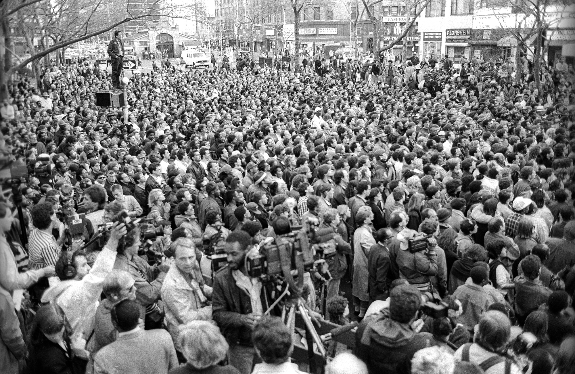 a large crowd of people gather in the streets