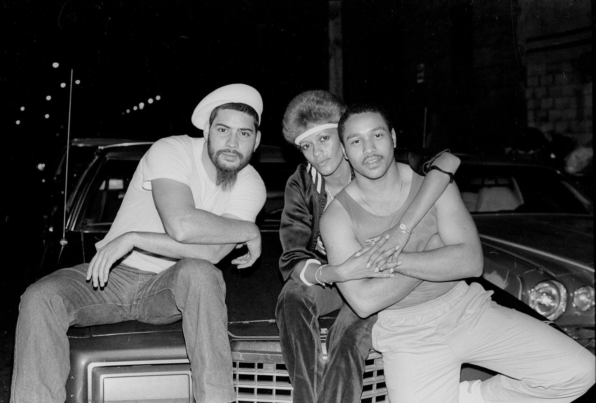 three people sat on the bonnet of a car