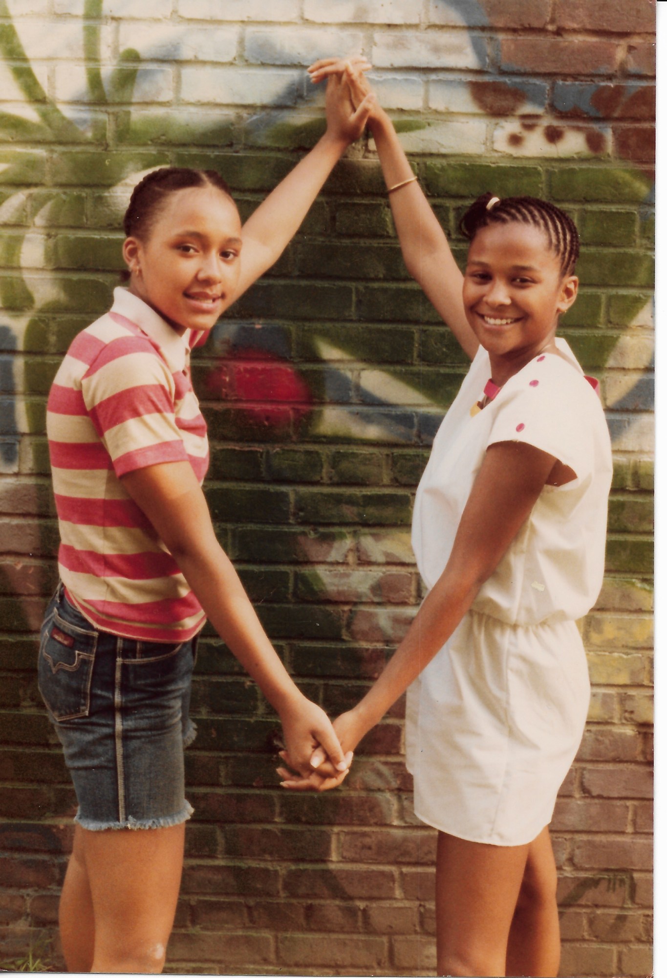 Two young girls posing for a portrait on the block in 1980.