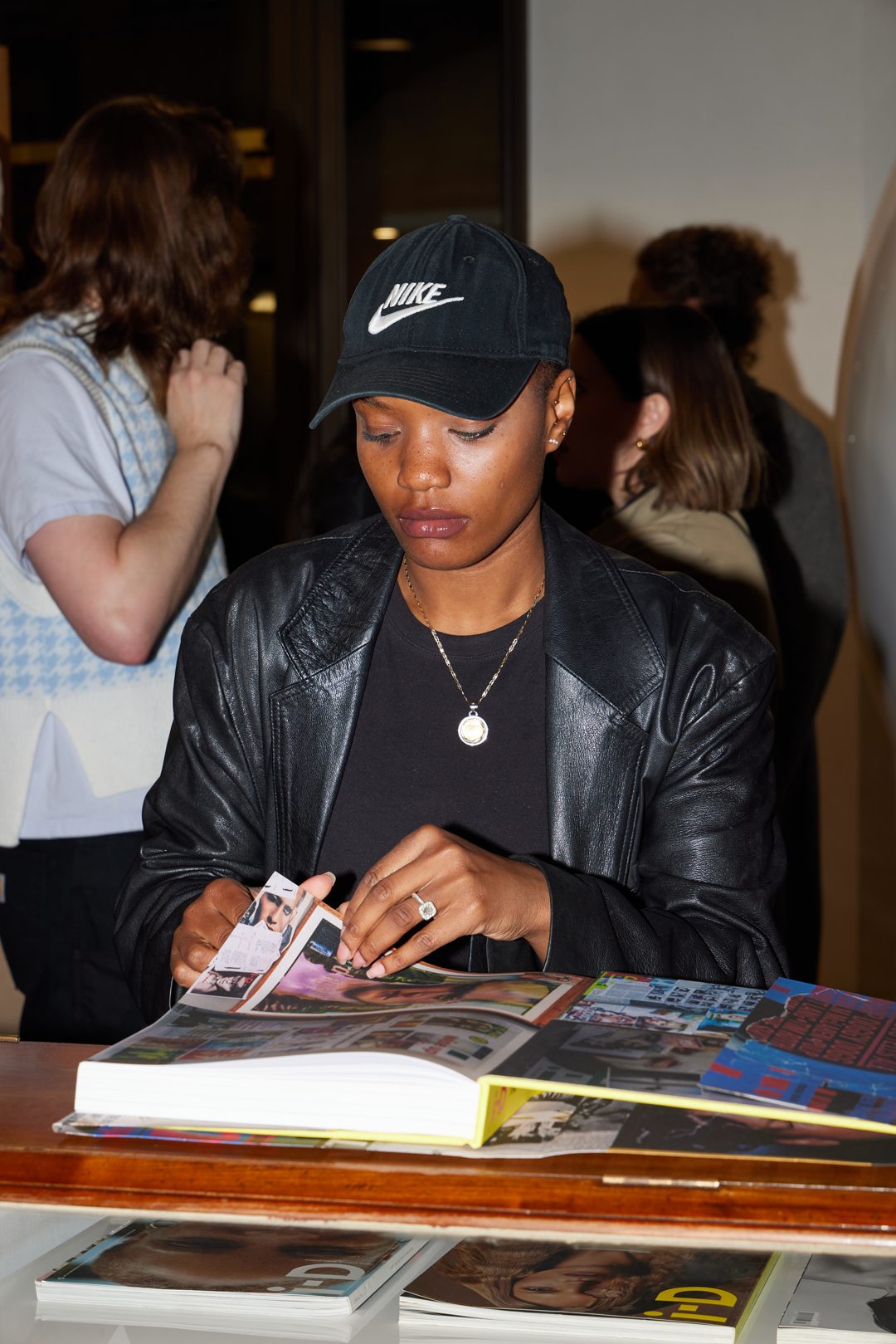 woman looks through i-d book at launch party 2022