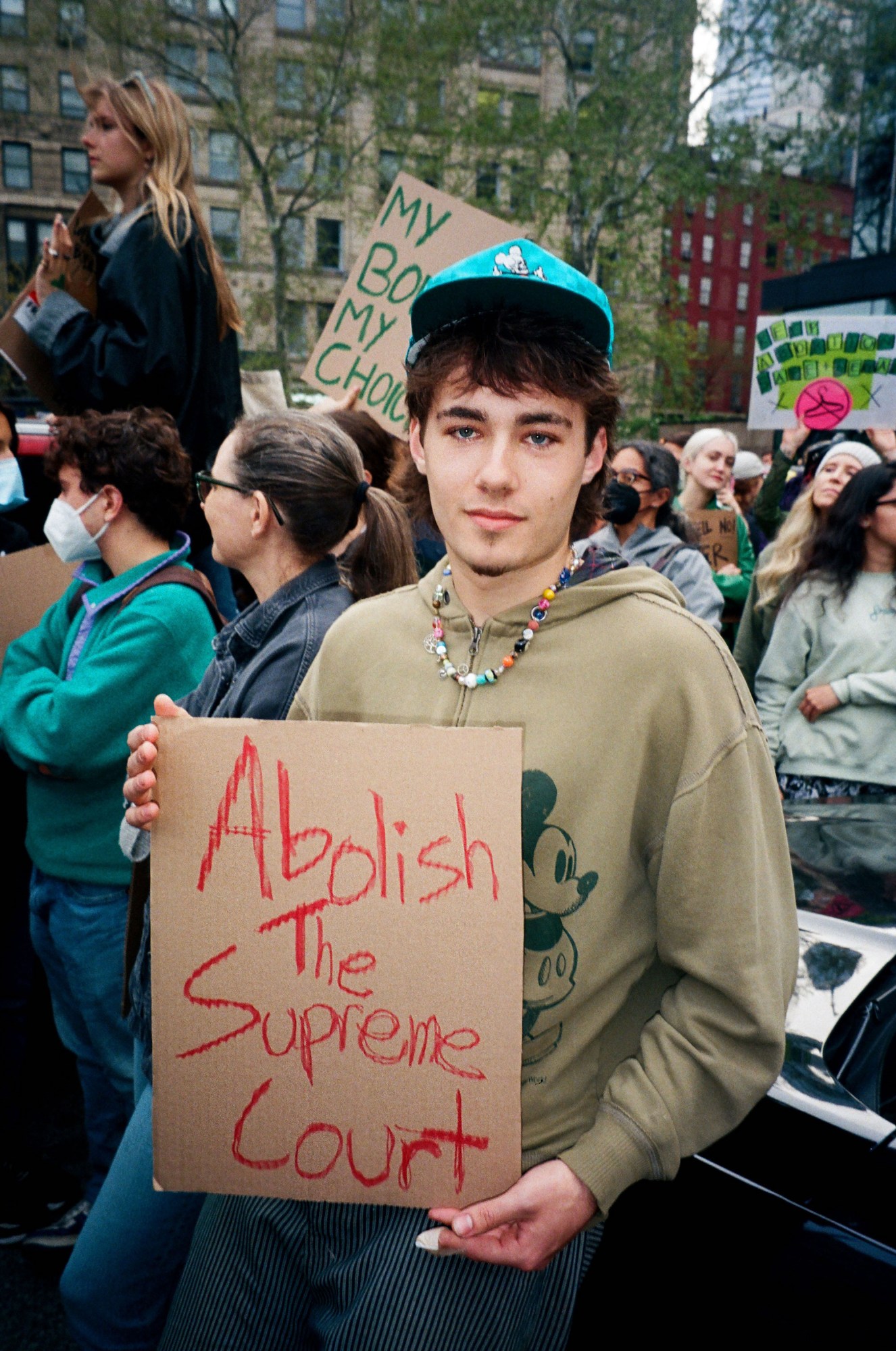 a protestor holding a sign that reads abolish the supreme court