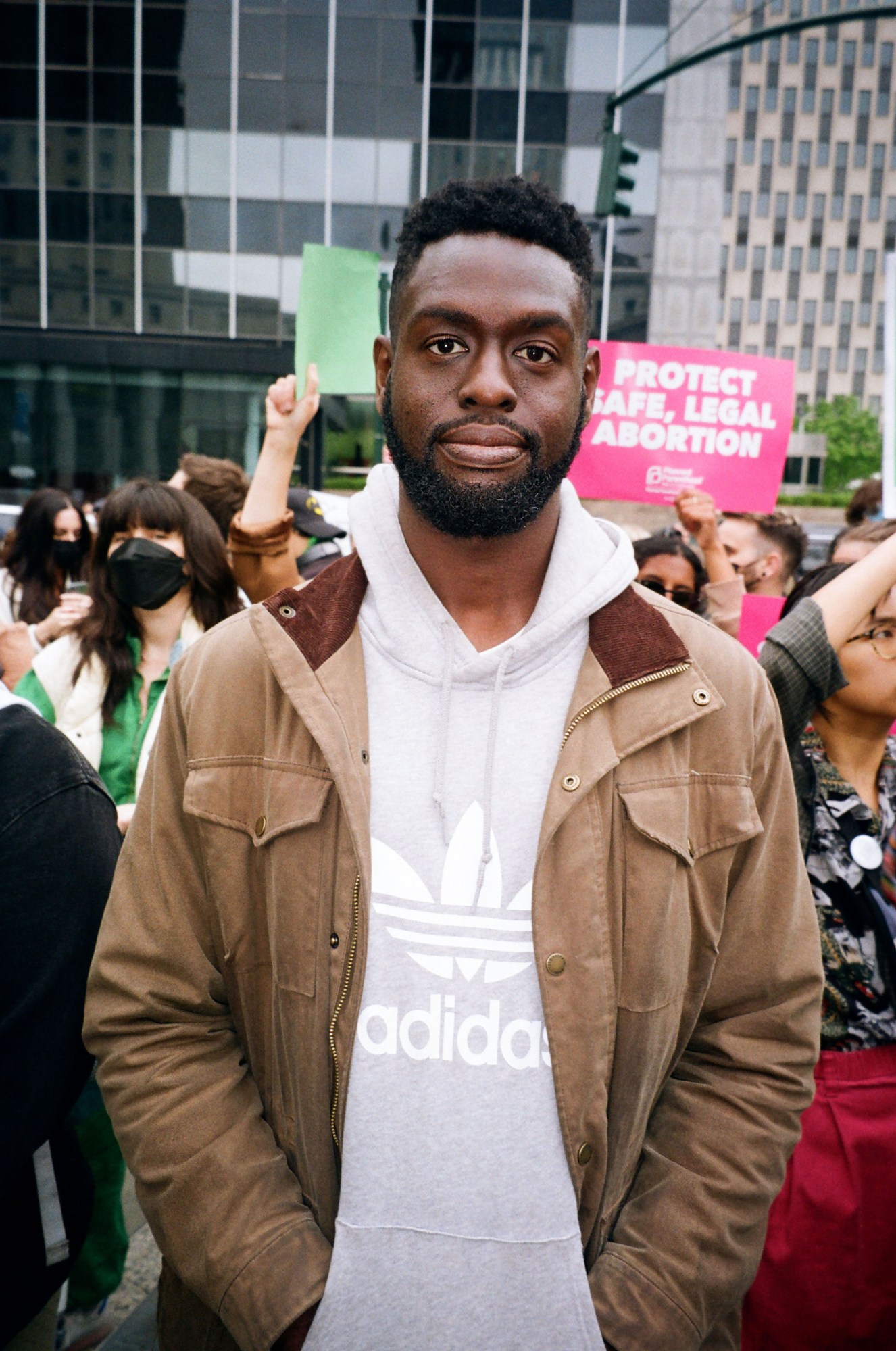 a protestor in an adidas hoodie standing in new york's foley square