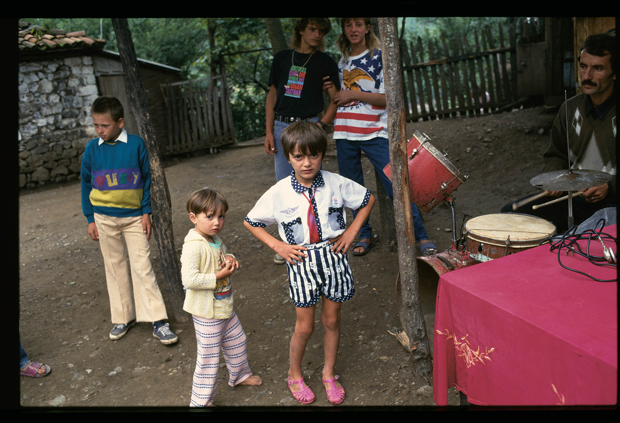 Children playing near a drum set in Eastern Europe.