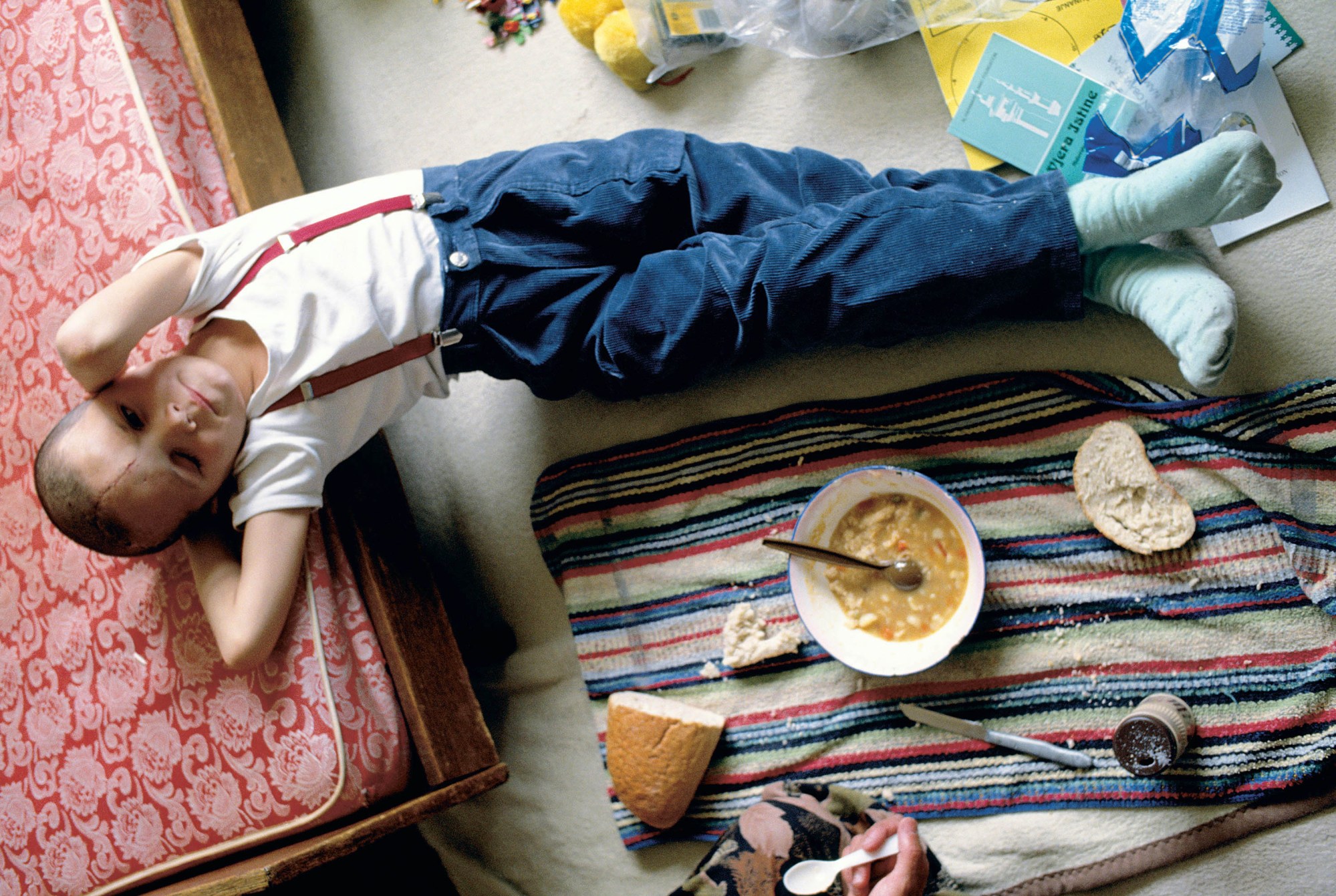 A young boy eating soup.