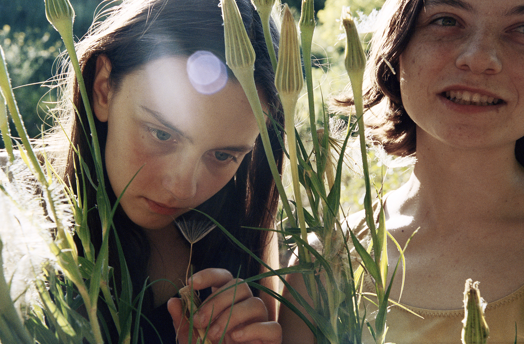 Two young girls playing in a field.