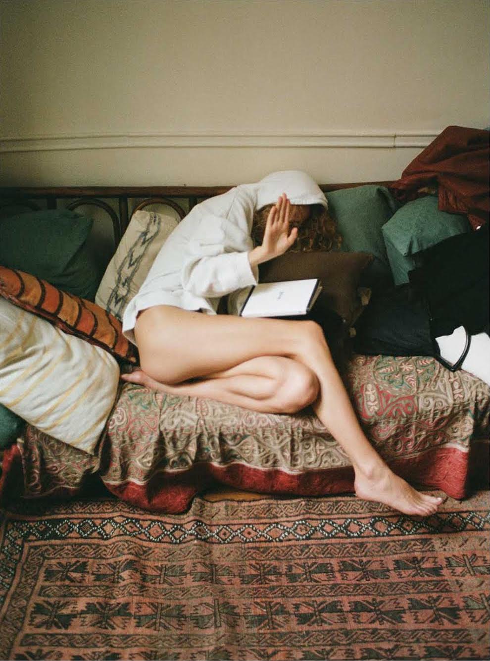 a photo of gemma janes on her couch with a book