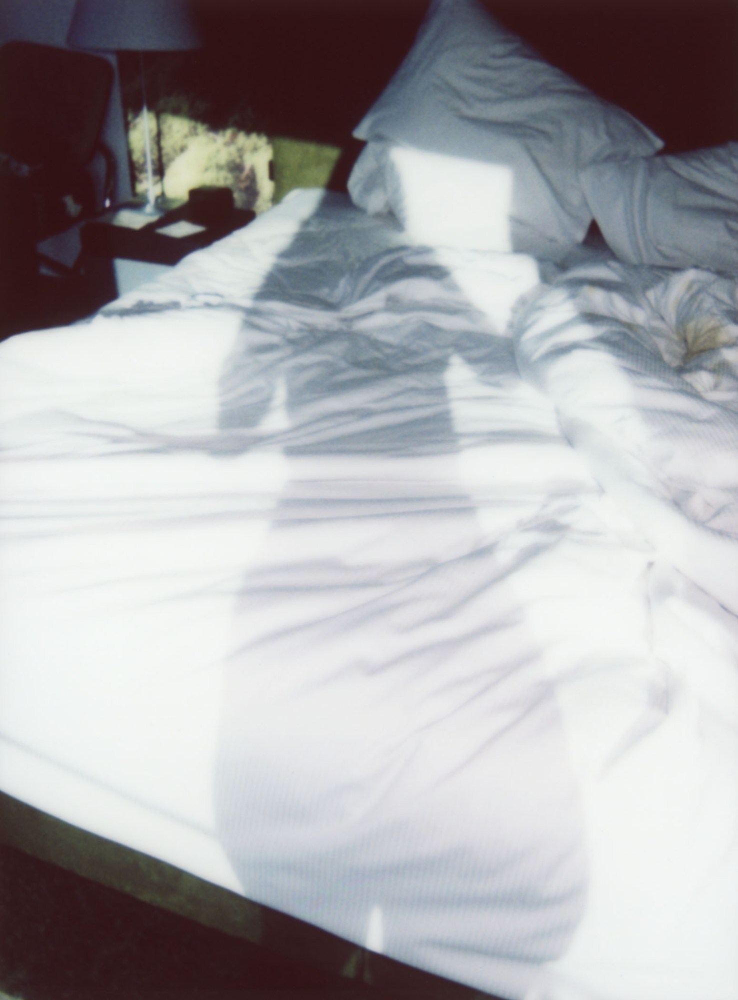 silhouette of a woman's shadow on a hotel bed