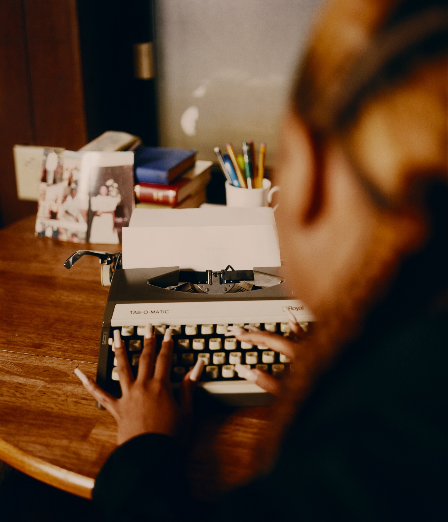 two hands with long nails typing on a typewriter photographed by kendall bessent for chucha studios