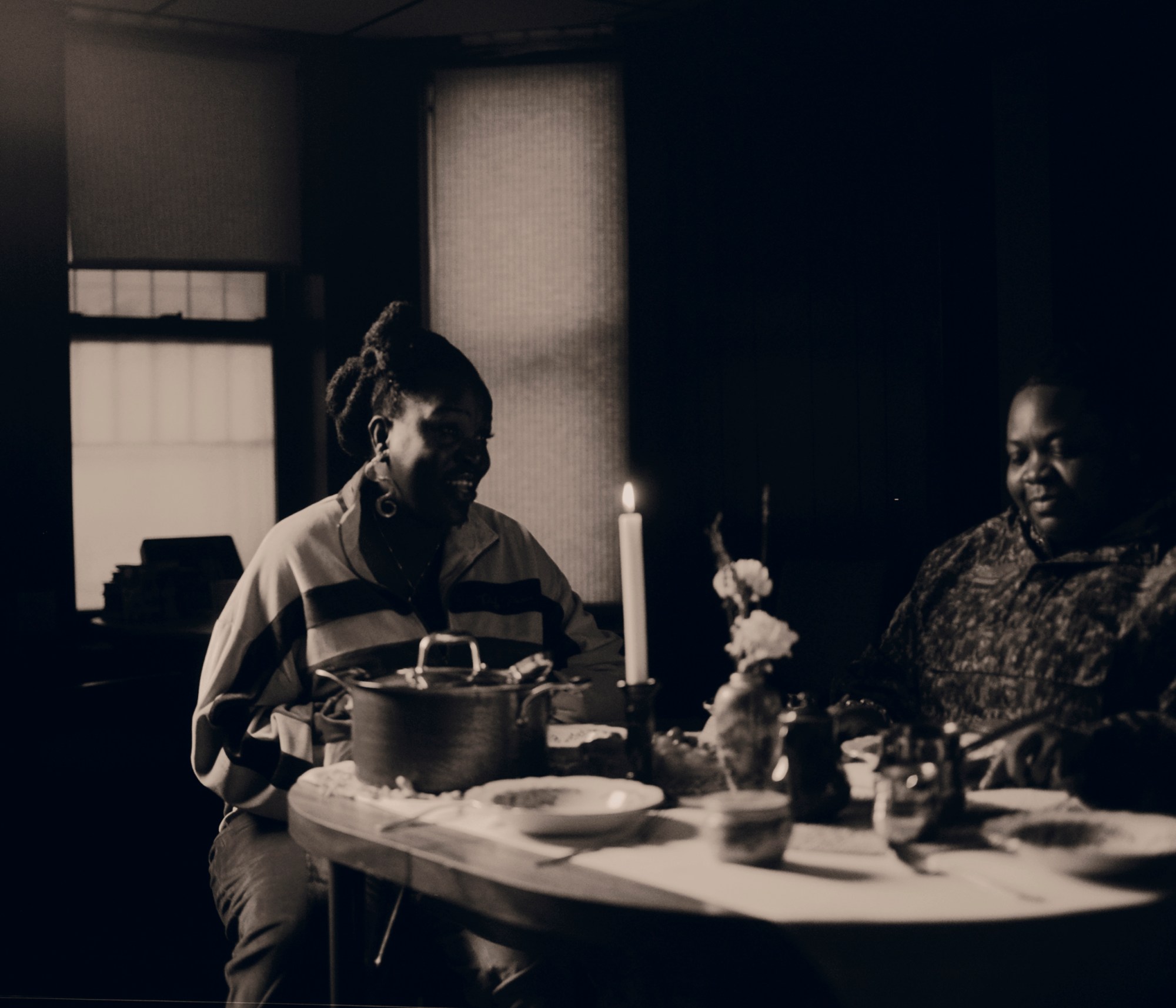 two women sitting at a dinner table with pots and plates photographed by kendall bessent for chucha studios