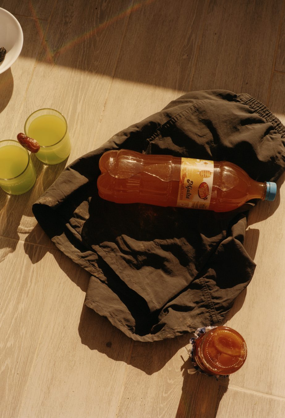 Juice, shorts and fruit in a jar on a table.