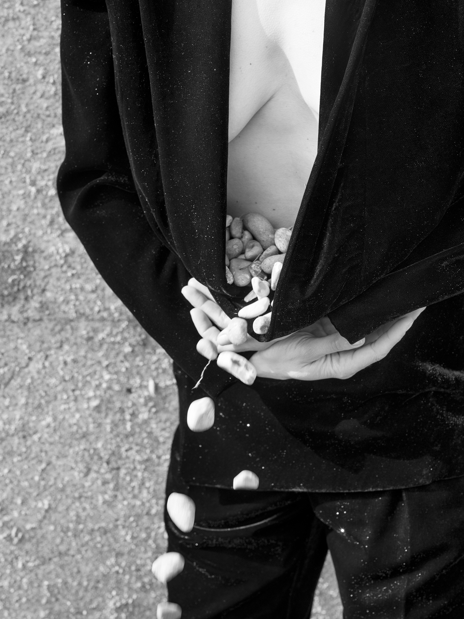 a woman gather pebbles in a jacket in a photo by olivia arthur