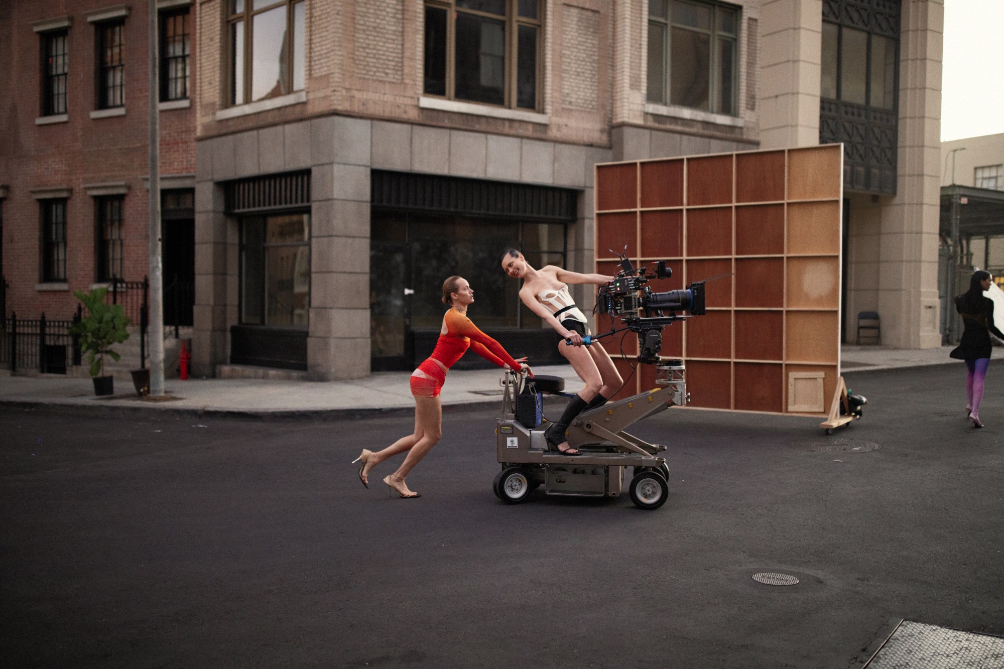 two models dressed in mugler pushing a camera around a hollywood set