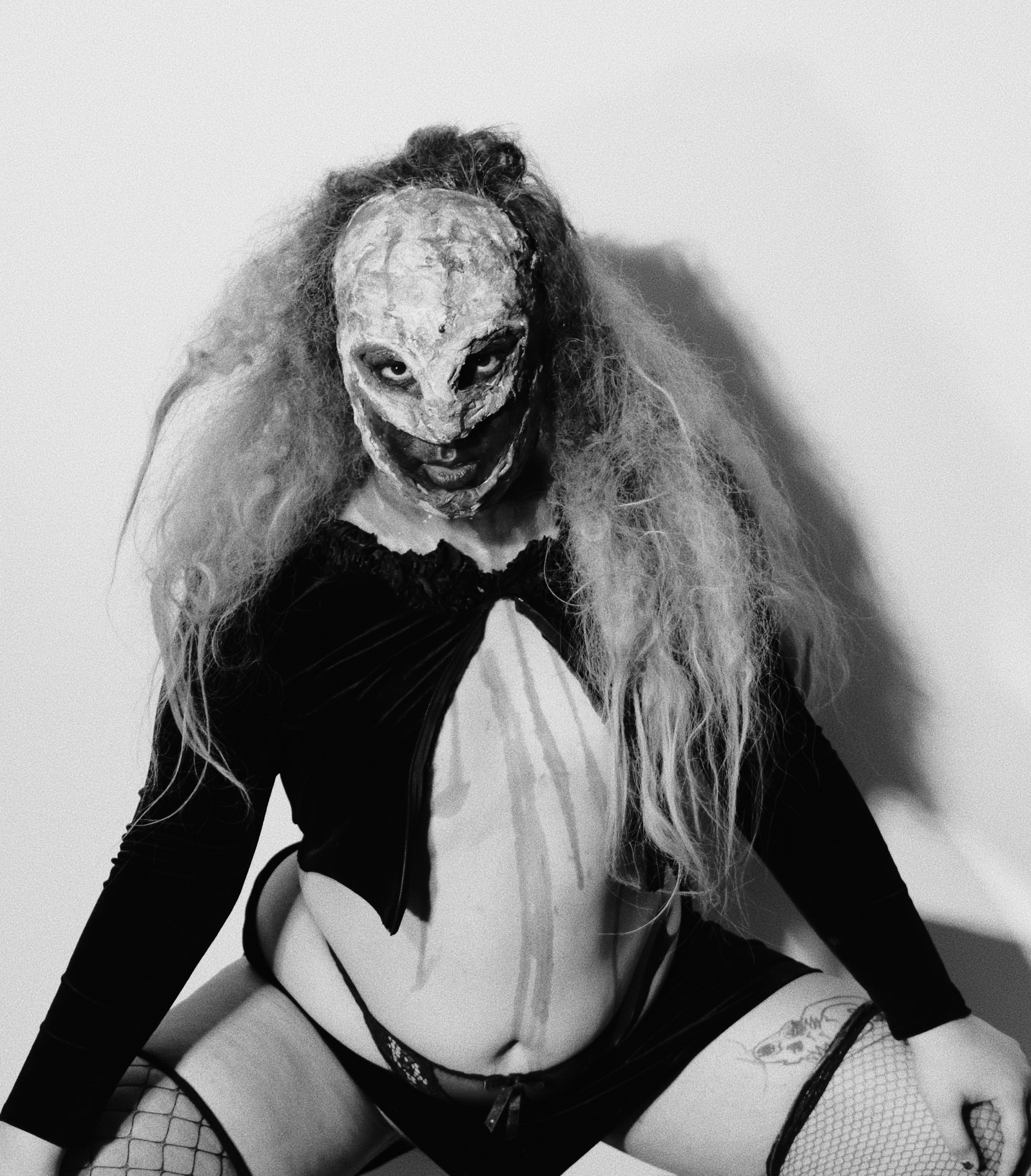 a drag performer wearing lingerie and a scary face mask