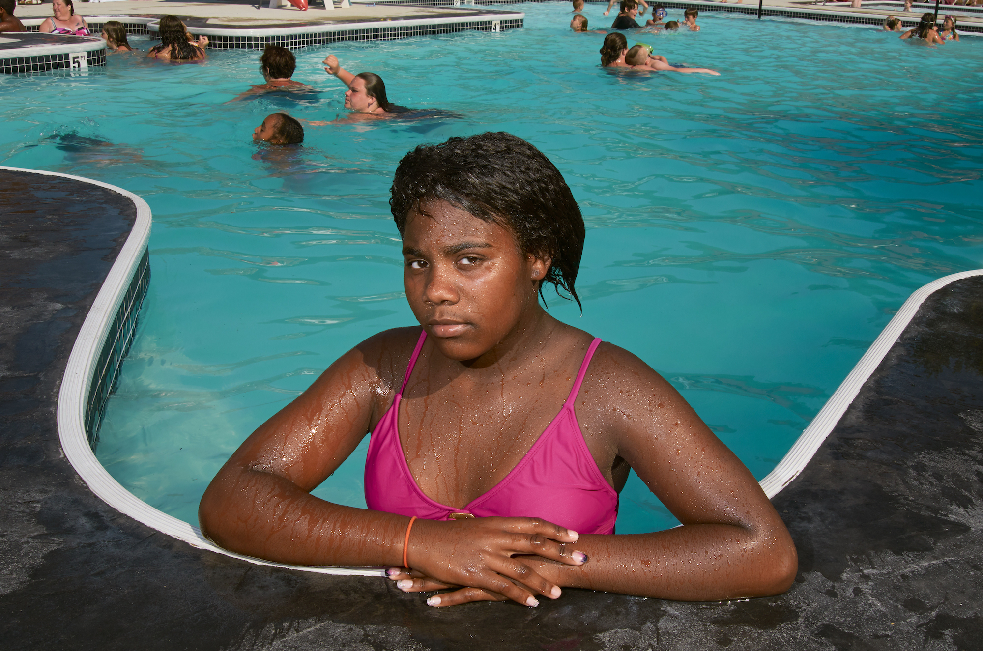 A young girl posing at a swimming pool