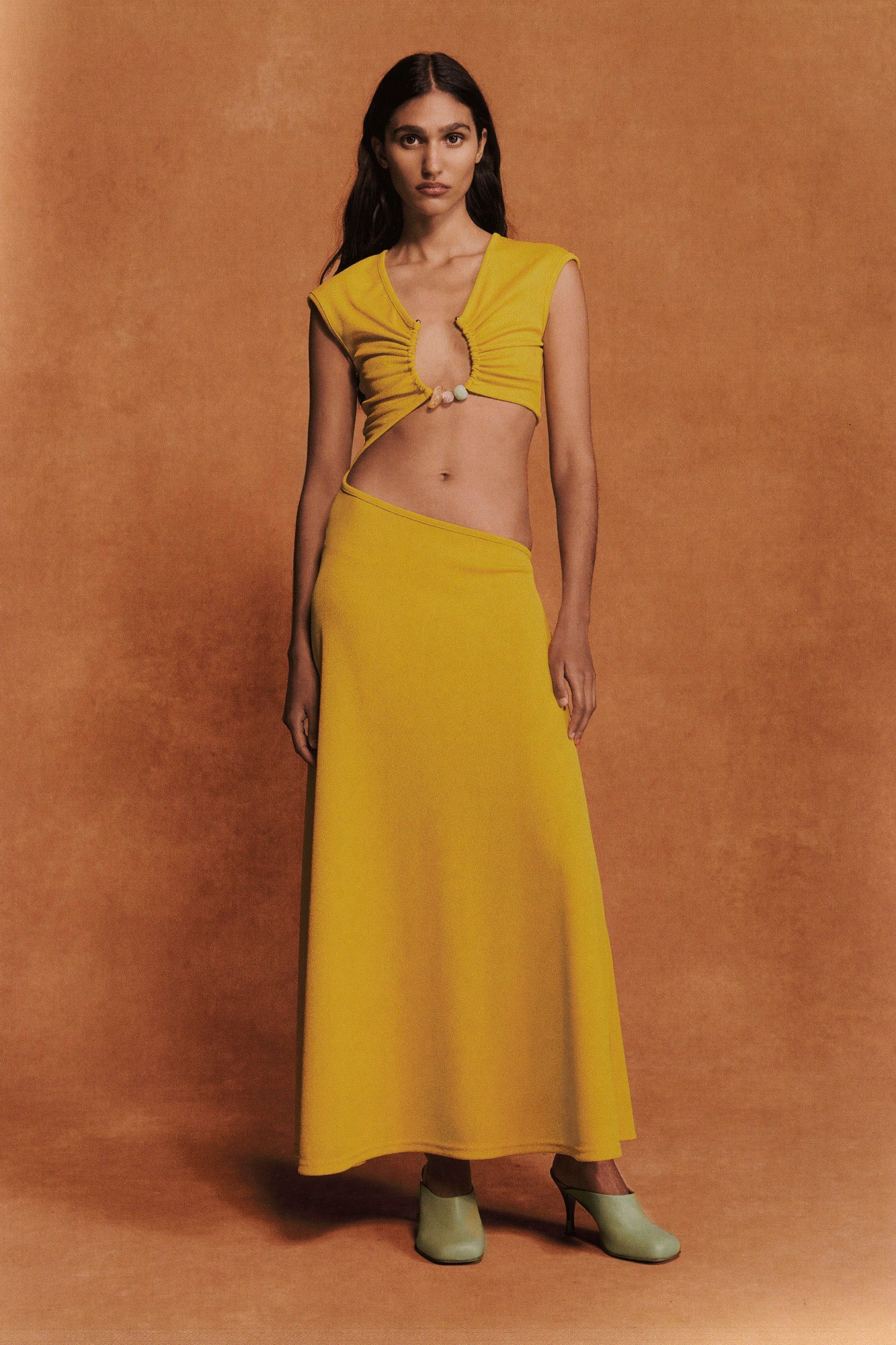 a model wearing a yellow skirt and top with crystal detail from christopher esber ss22