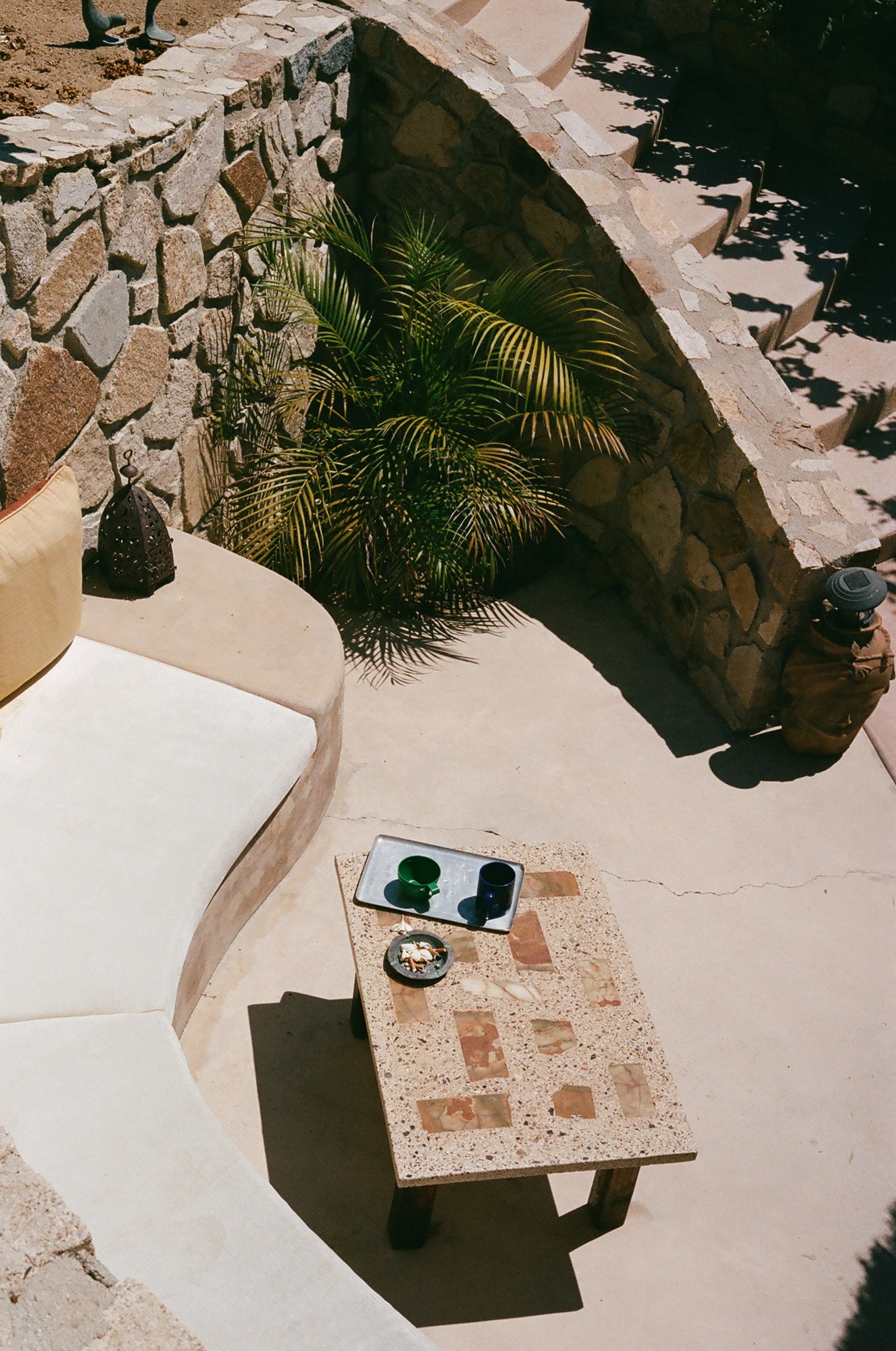 a seating alcove with cigarette butts and empty glasses on a stone table