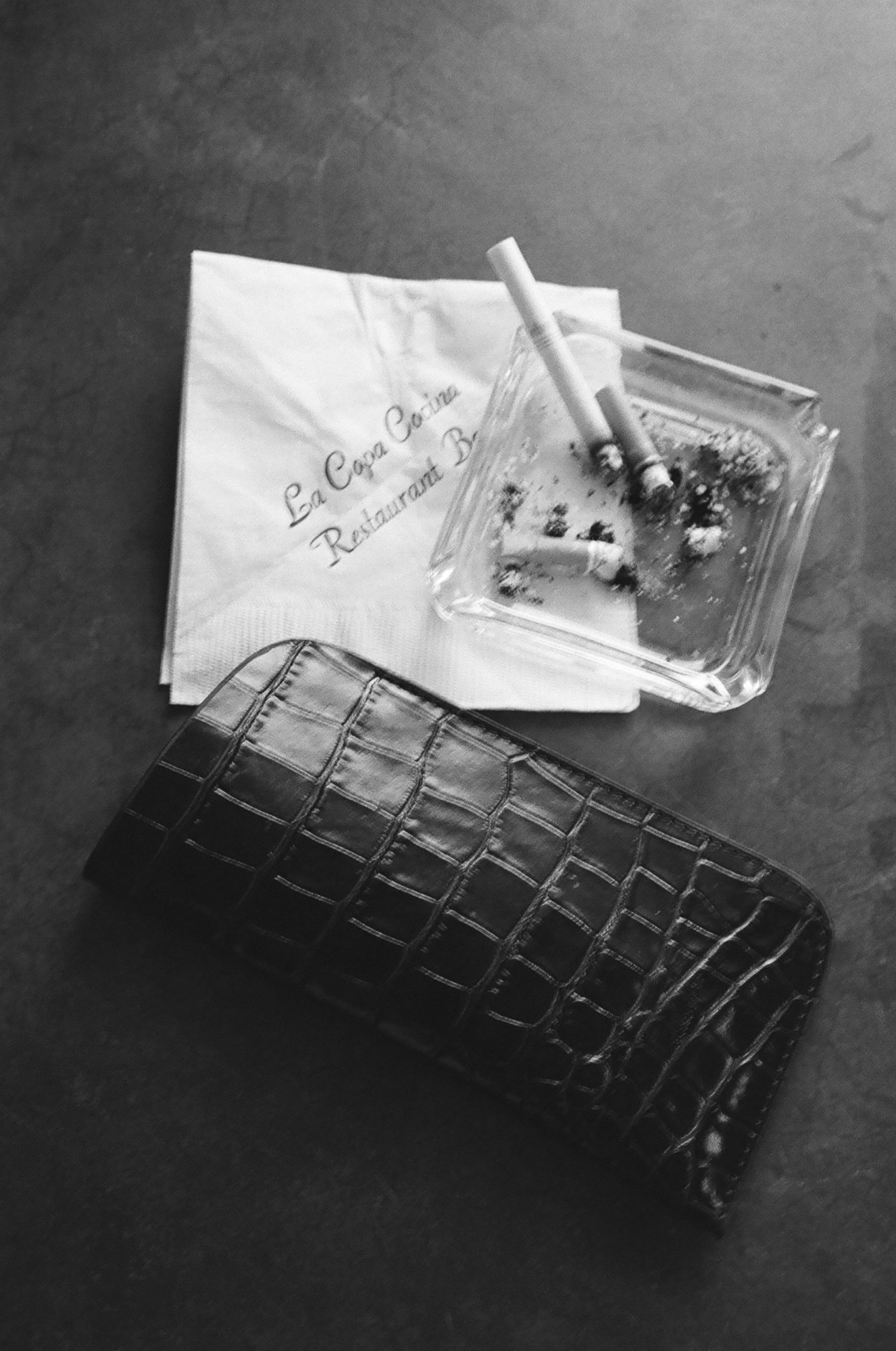 a wallet sitting next to a napkin and ashtray