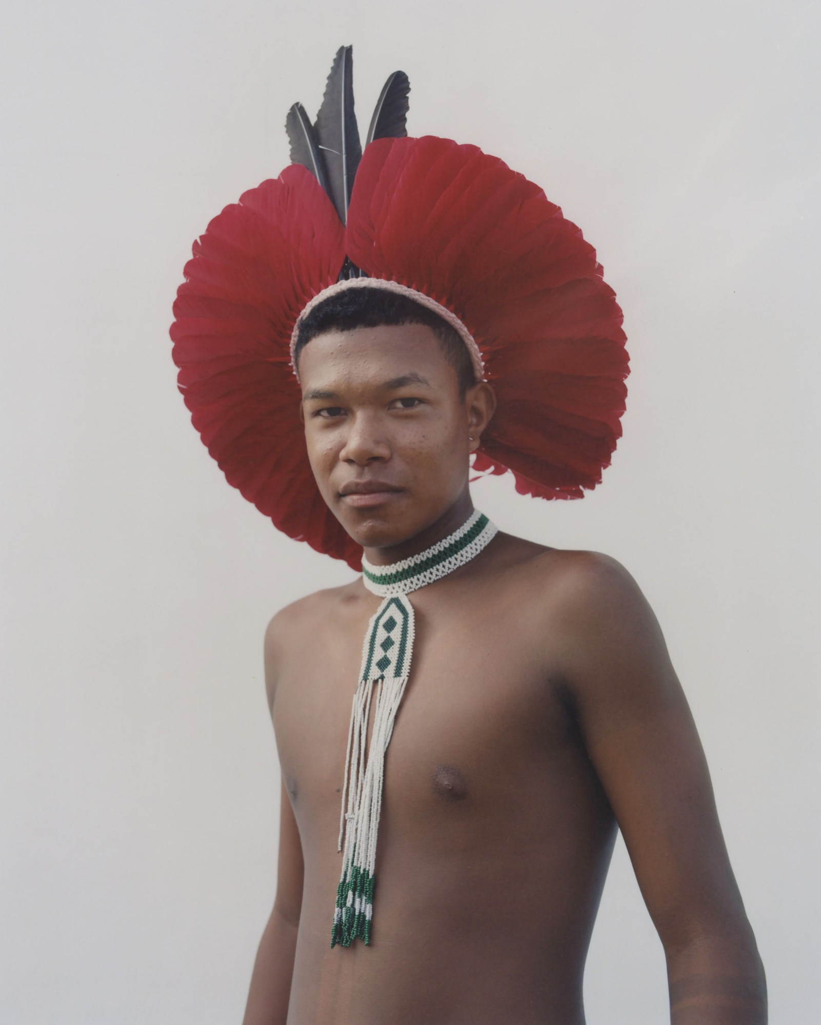 close up of protester wearing traditional indigenous clothing standing against a wall