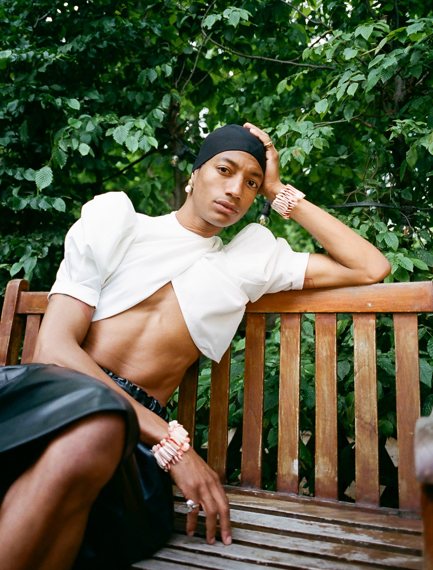 MJ Harper photographed by Rae Tilly sitting on a bench in a garden