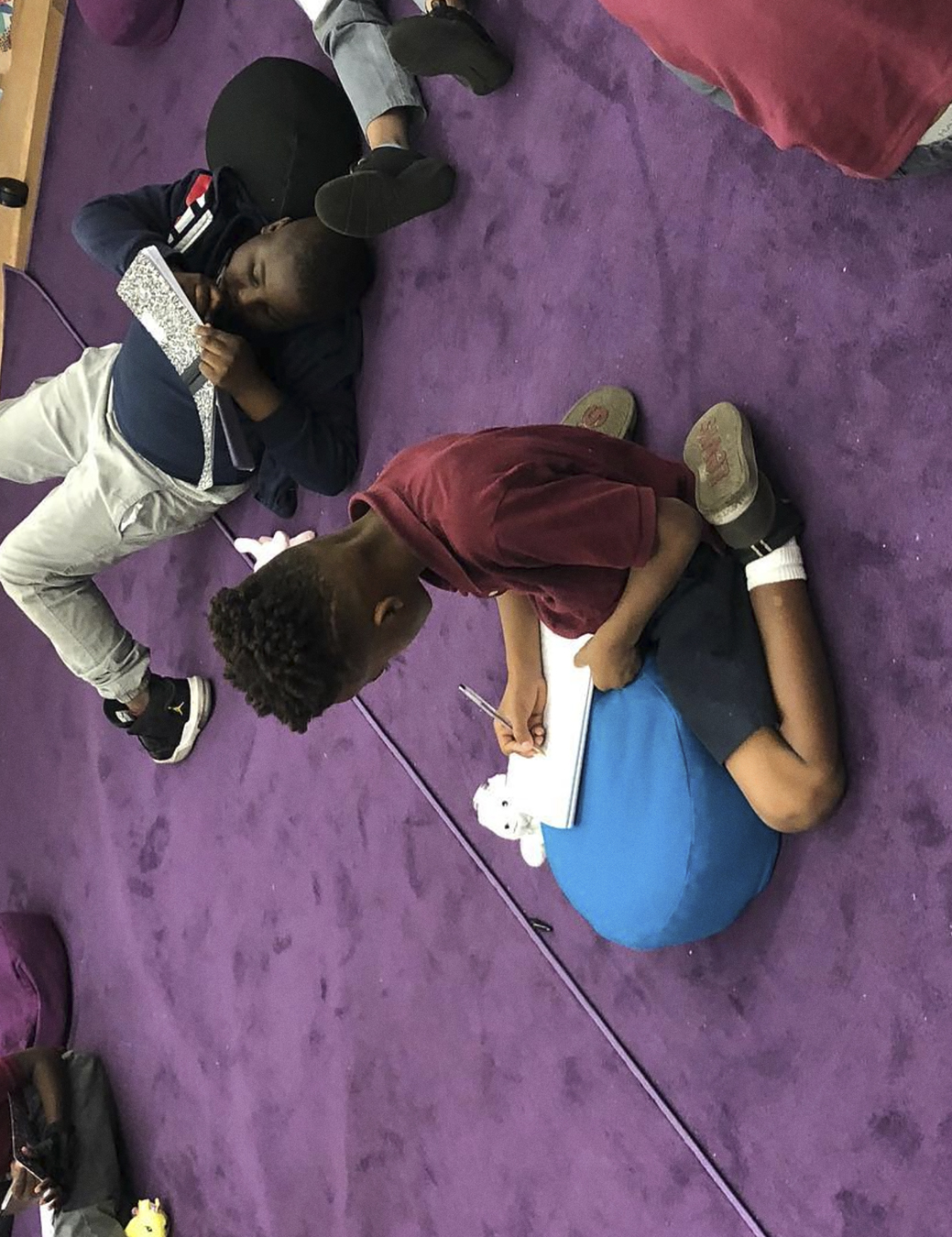 Children on the floor writing and drawing