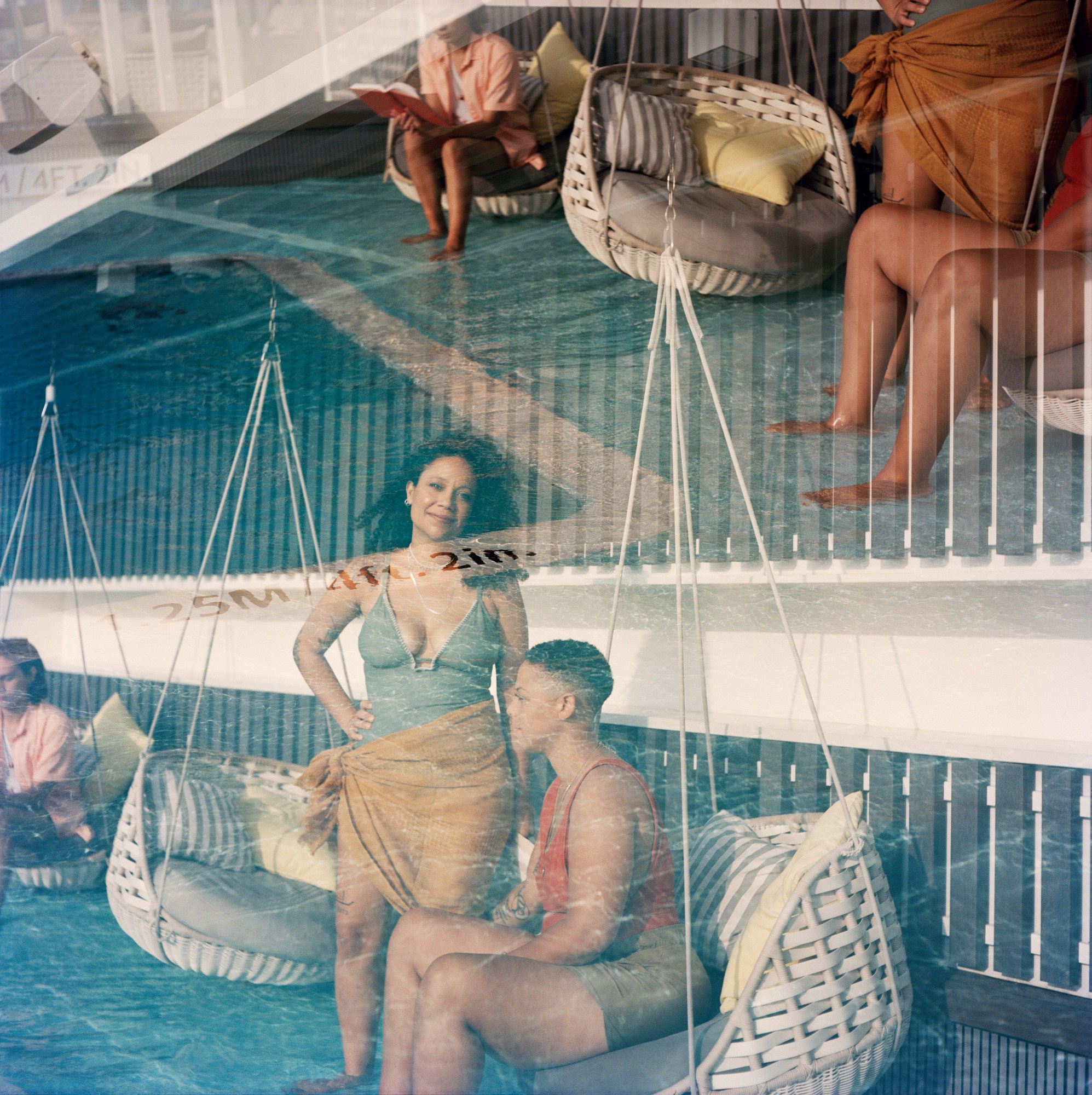 a woman standing next to her partner reflected in a mirror at the beach