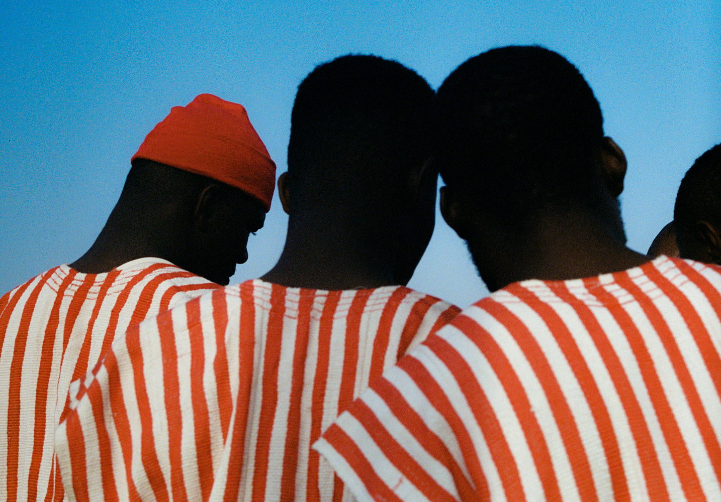 Three men wearing matching striped tops